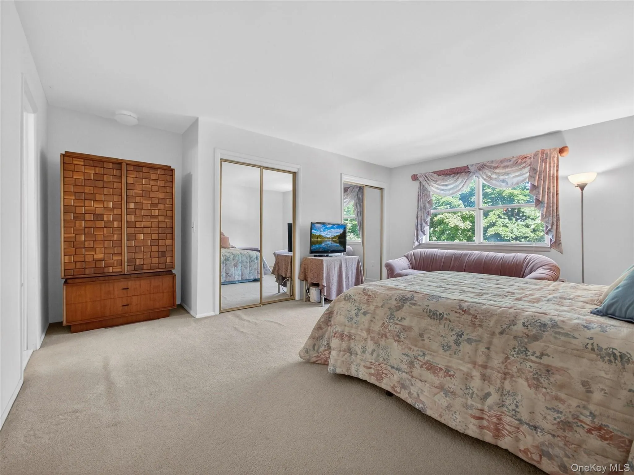 Alternate view of the spacious primary bedroom showcasing ample closet storage. Alternate view of the spacious primary bedroom showcasing ample closet storage.