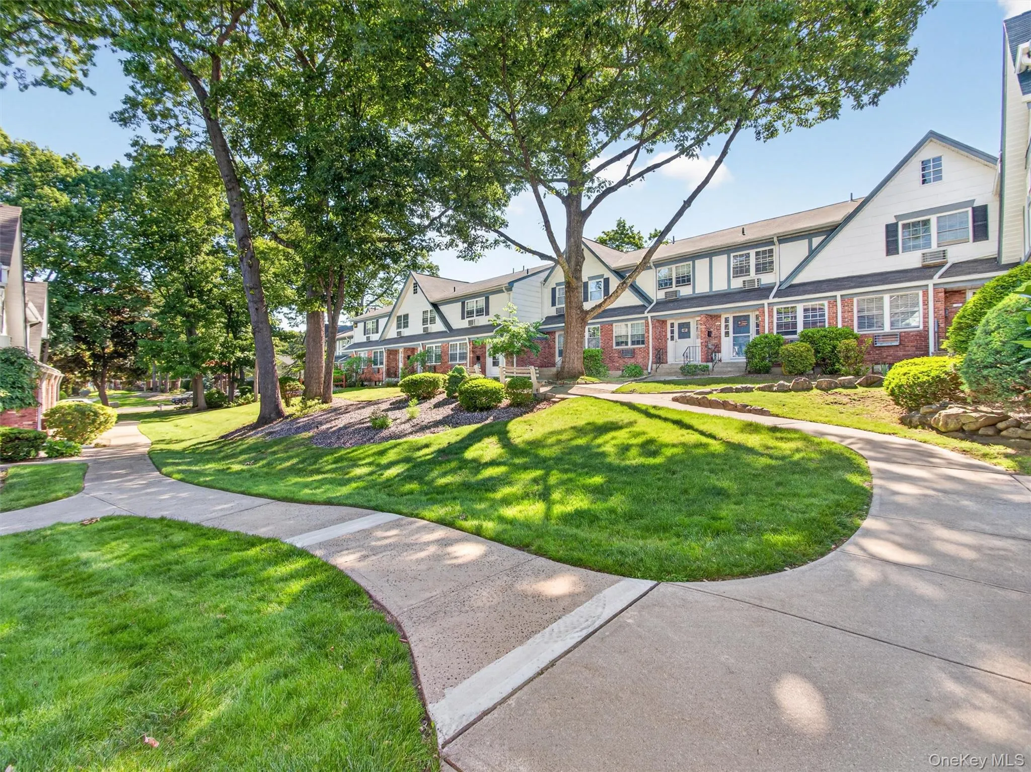 Beautifully landscaped courtyard with mature shade trees and inviting walkways. Beautifully landscaped courtyard with mature shade trees and inviting walkways.