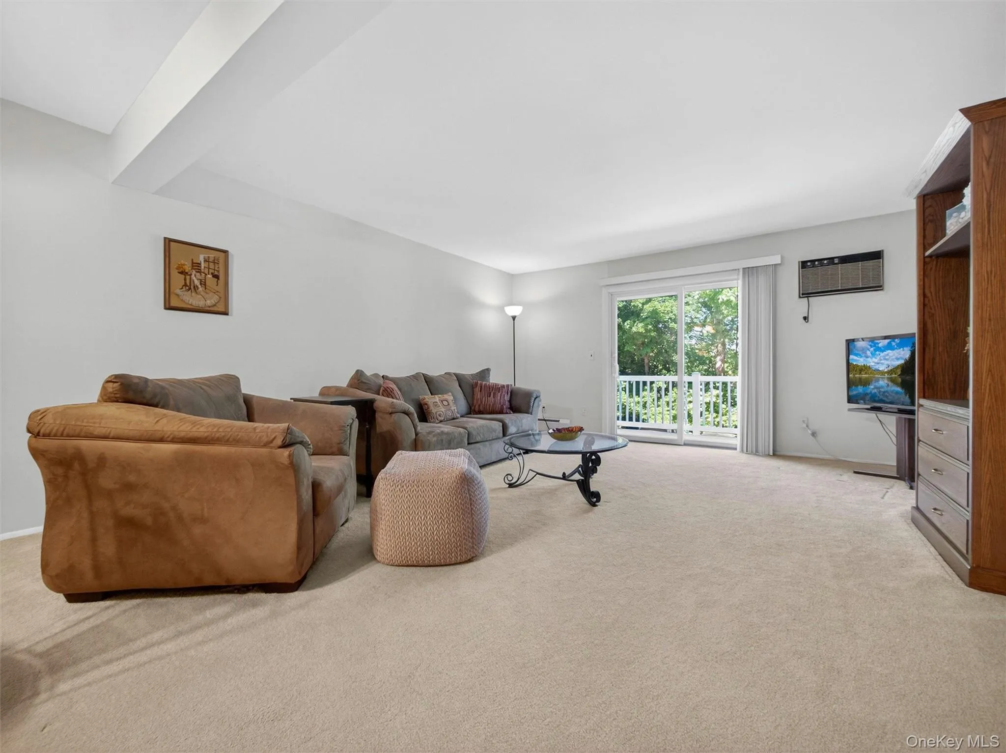 Spacious living room with abundant natural light and sliding glass doors leading to outdoor space. Spacious living room with abundant natural light and sliding glass doors leading to outdoor space.