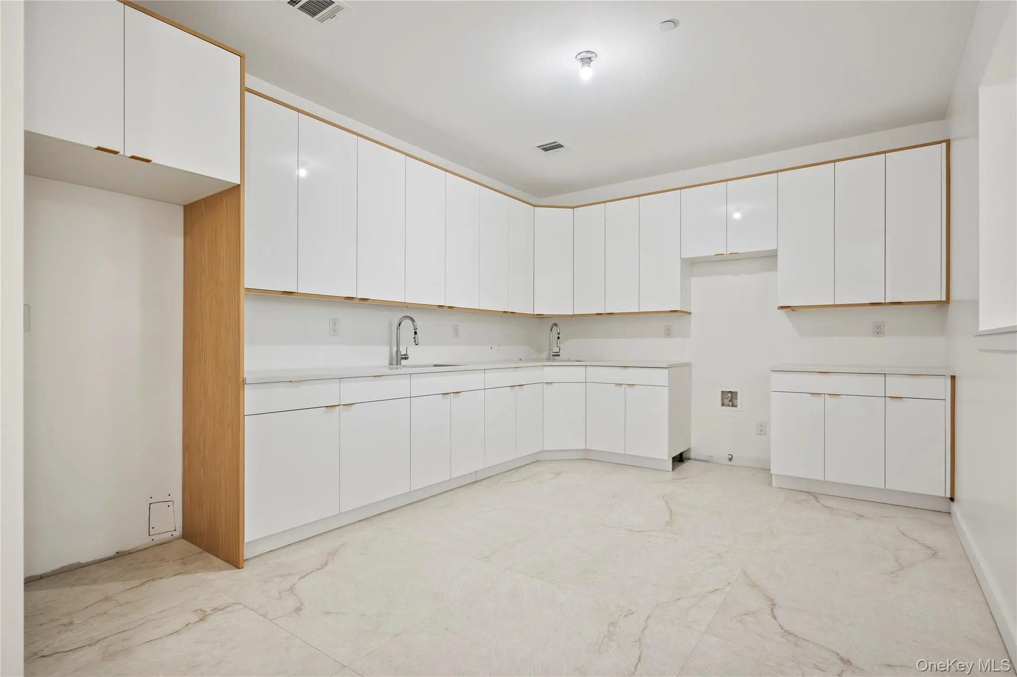 Kitchen featuring white cabinets, light countertops, and modern cabinets Kitchen featuring white cabinets, light countertops, and modern cabinets