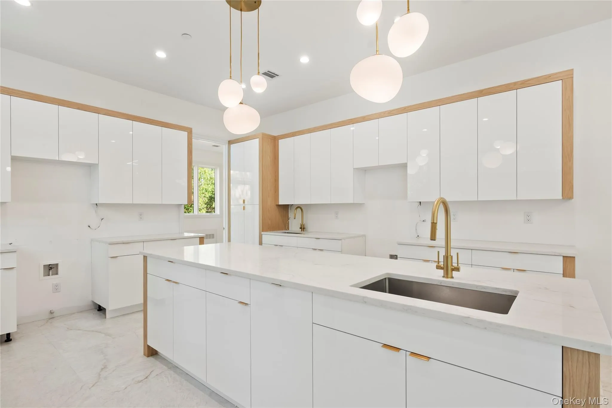 Kitchen with hanging light fixtures, white cabinetry, light stone counters, modern cabinets, and recessed lighting Kitchen with hanging light fixtures, white cabinetry, light stone counters, modern cabinets, and recessed lighting