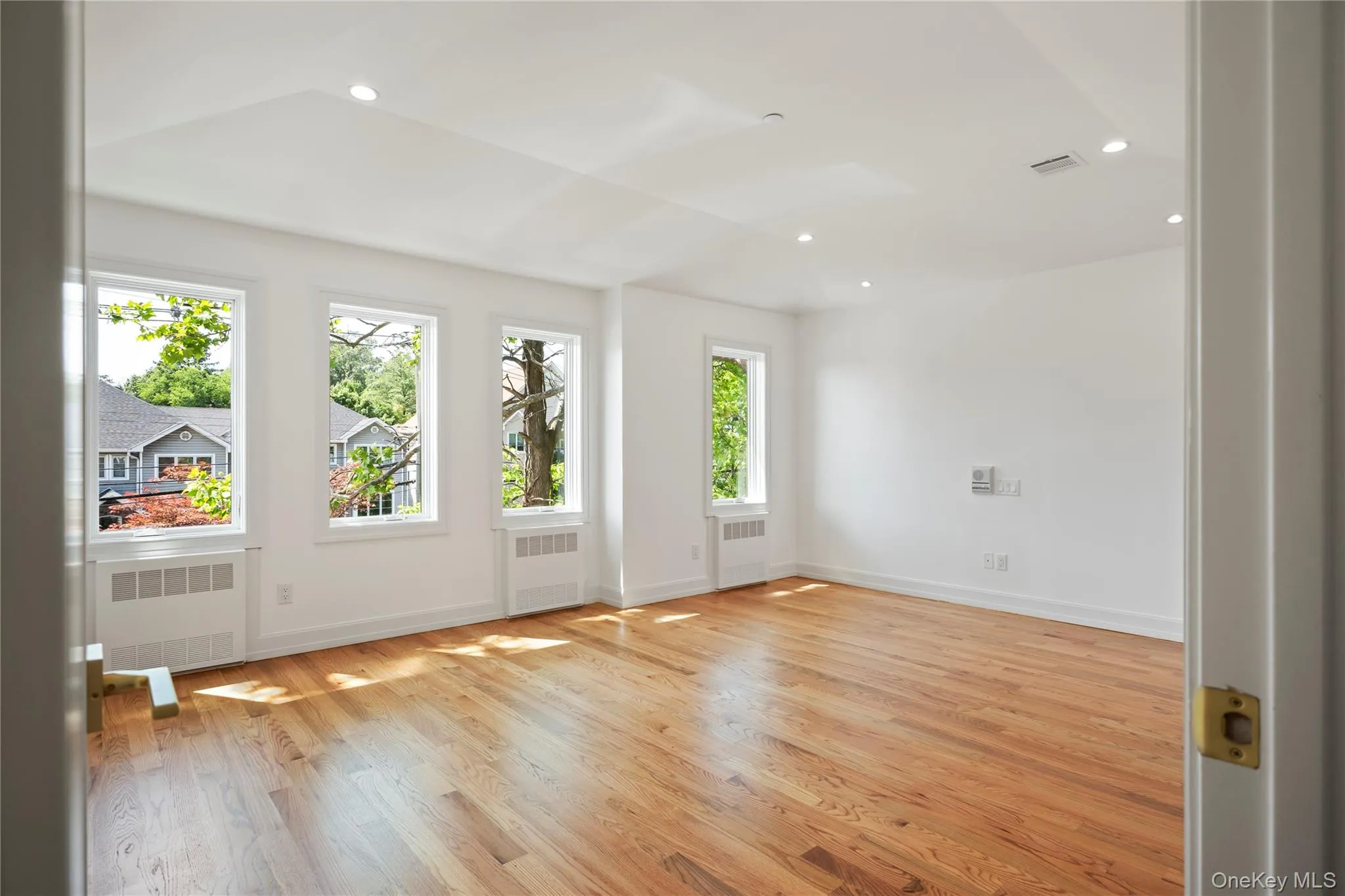 Spare room featuring light wood-type flooring, recessed lighting, and radiator Spare room featuring light wood-type flooring, recessed lighting, and radiator