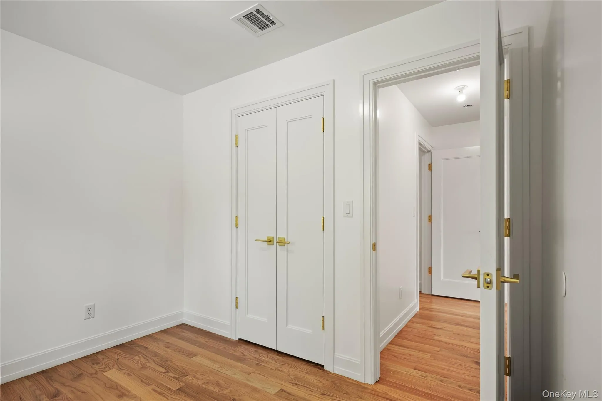 Unfurnished bedroom with light wood-type flooring and a closet Unfurnished bedroom with light wood-type flooring and a closet