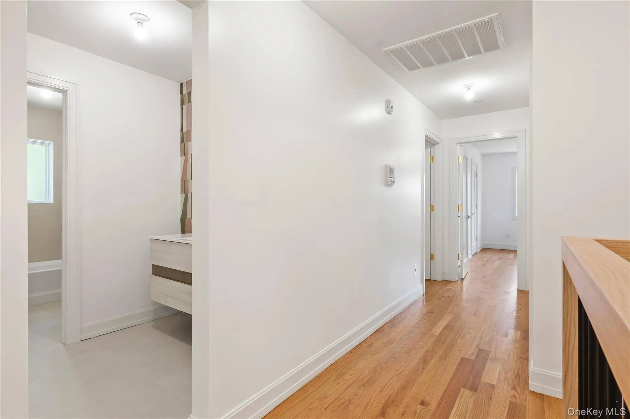 Hall featuring baseboards and light wood-style floors Hall featuring baseboards and light wood-style floors