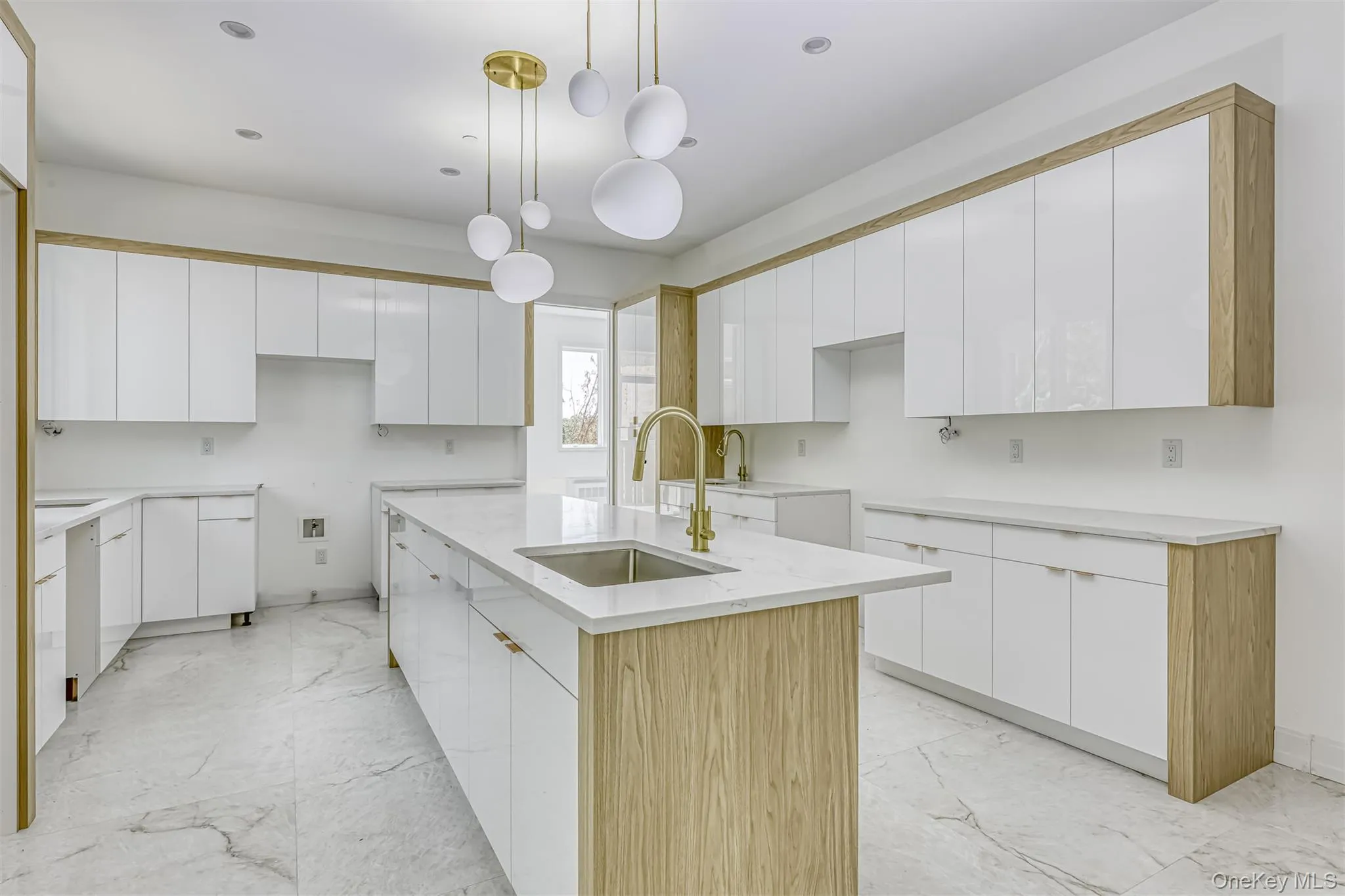 Kitchen featuring white cabinetry, hanging light fixtures, light marble finish flooring, and recessed lighting Kitchen featuring white cabinetry, hanging light fixtures, light marble finish flooring, and recessed lighting