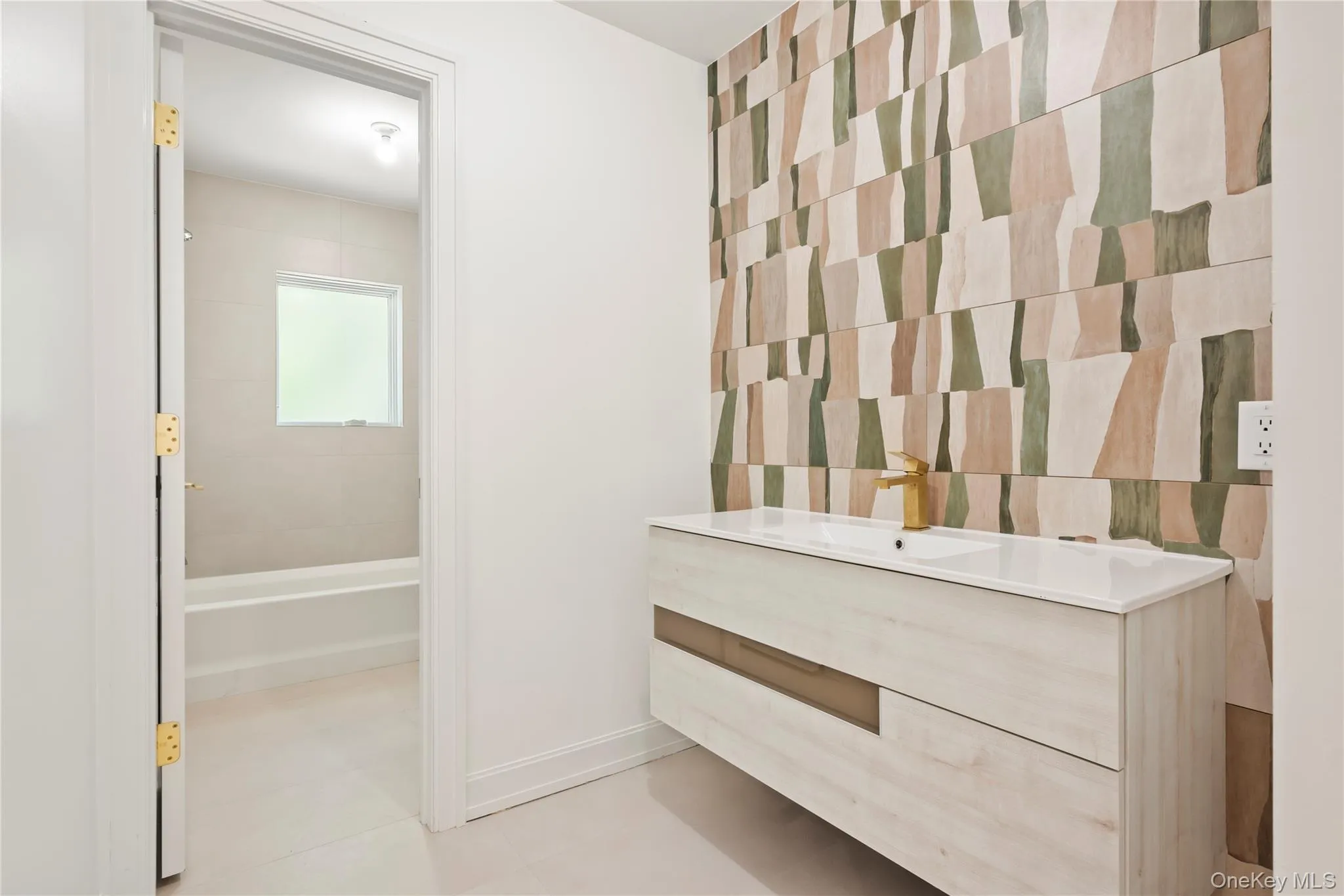 Bathroom with vanity, shower combination, light tile patterned floors, and tile walls Bathroom with vanity, shower combination, light tile patterned floors, and tile walls