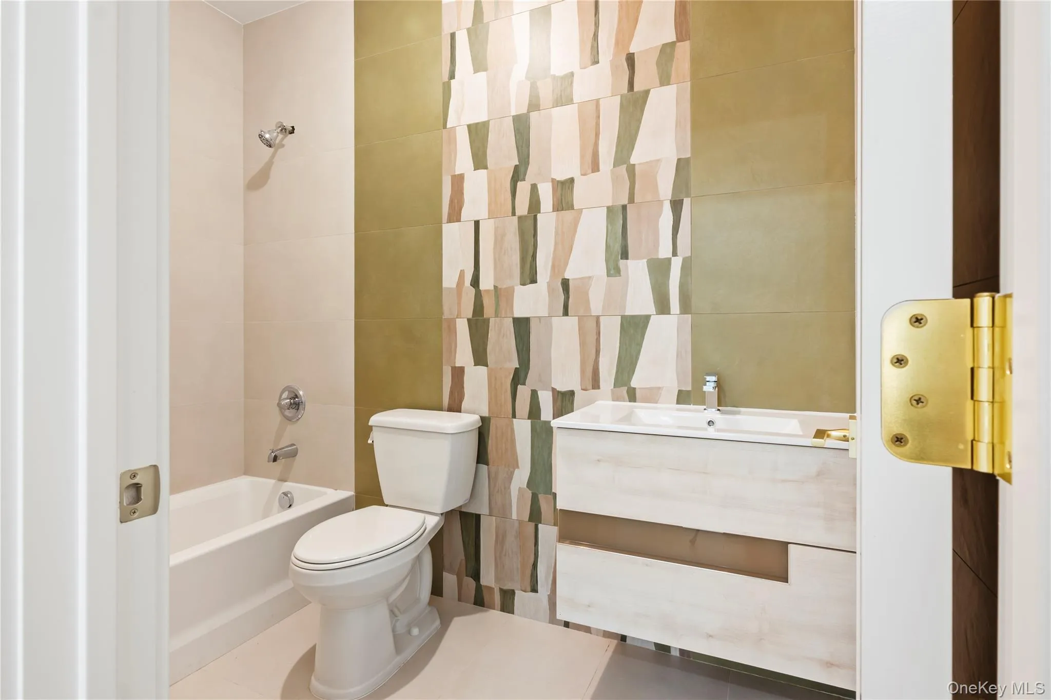 Bathroom featuring bathtub / shower combination, vanity, and tile walls Bathroom featuring bathtub / shower combination, vanity, and tile walls
