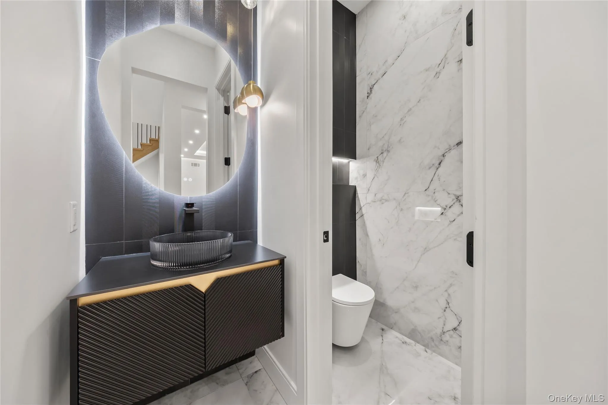 Modern powder room featuring a floating vanity with a fluted vessel sink, back-lit mirror, and matte black fixtures Modern powder room featuring a floating vanity with a fluted vessel sink, back-lit mirror, and matte black fixtures