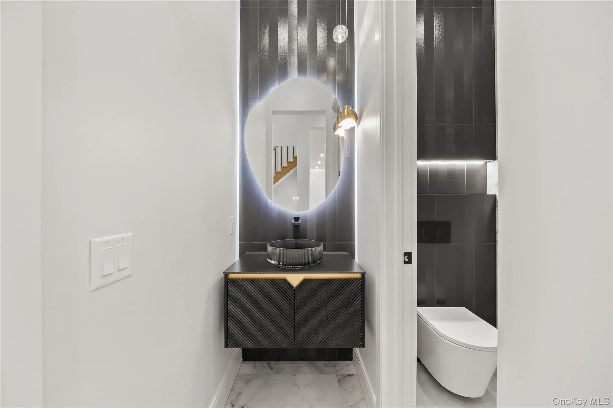 Contemporary powder room featuring a floating vanity with a vessel sink, back-lit mirror, and modern pendant lighting, expensive wall hung toilet, Contemporary powder room featuring a floating vanity with a vessel sink, back-lit mirror, and modern pendant lighting, expensive wall hung toilet,