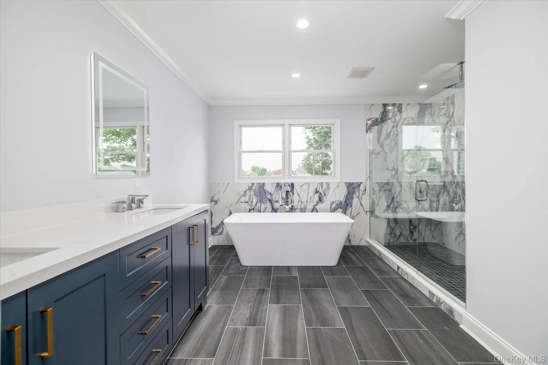 Primary bathroom complete with a large walk-in shower, a soaker tub, and a double sink Primary bathroom complete with a large walk-in shower, a soaker tub, and a double sink