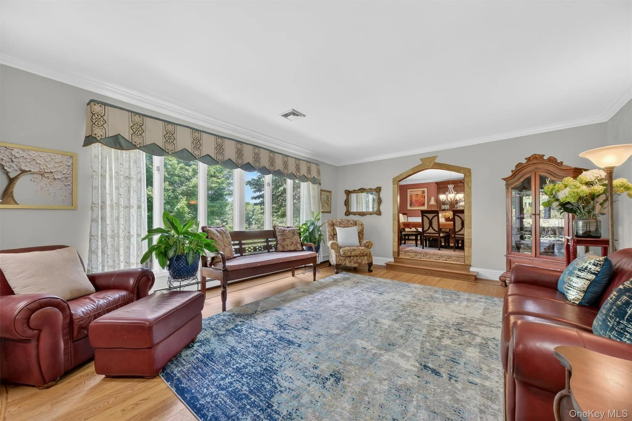 Light-filled formal living room with crown molding and hardwood floors. Light-filled formal living room with crown molding and hardwood floors.