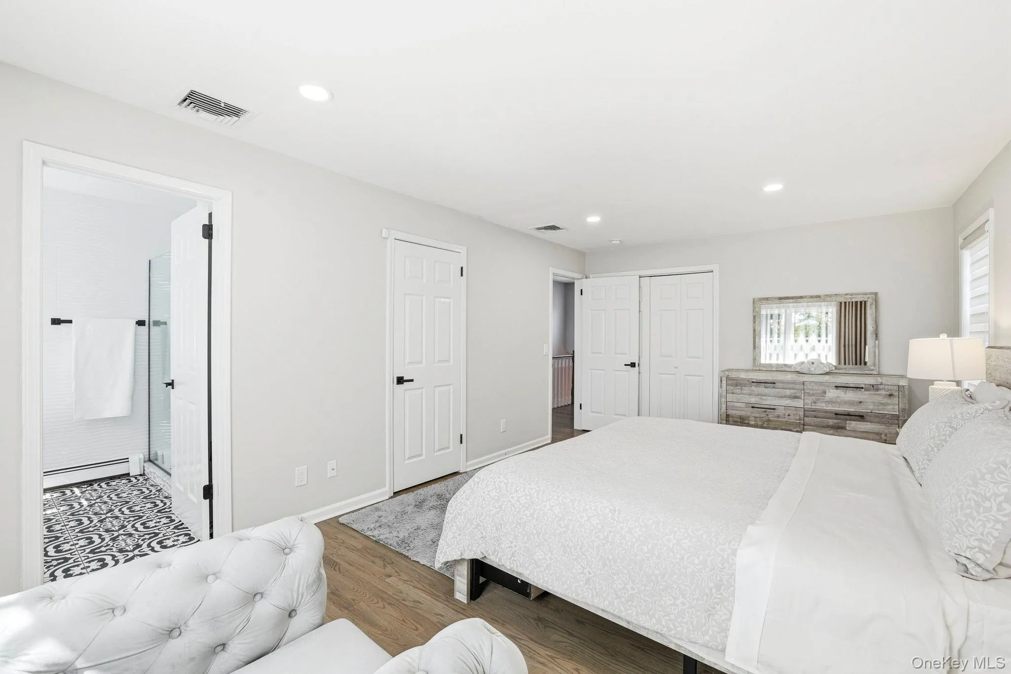 Spacious room featuring wood-finish flooring, recessed lighting, and white walls Spacious room featuring wood-finish flooring, recessed lighting, and white walls