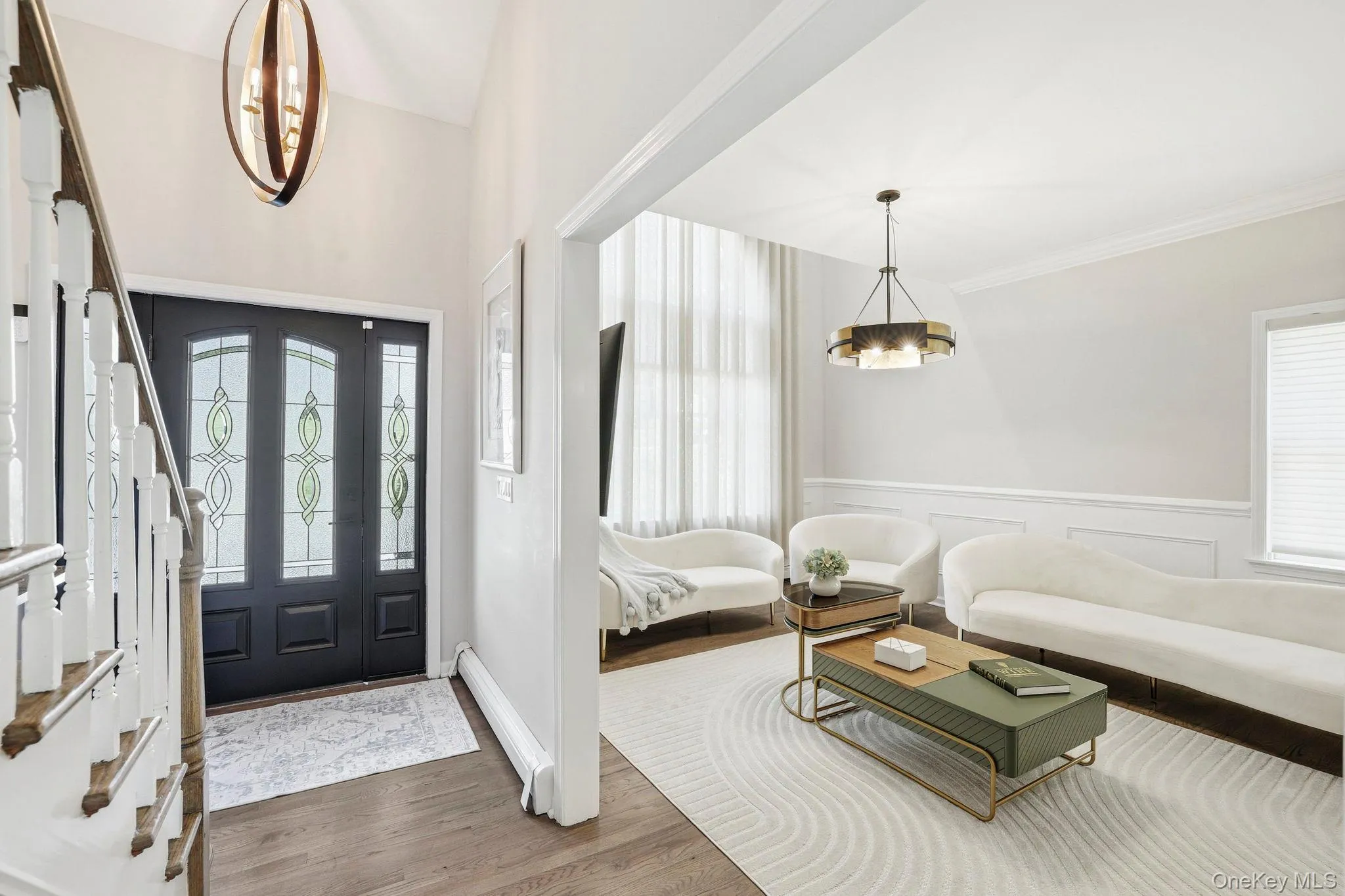 Entryway featuring a dark wood door with decorative glass panels, wood-finish flooring, and a contemporary spherical chandelier Entryway featuring a dark wood door with decorative glass panels, wood-finish flooring, and a contemporary spherical chandelier