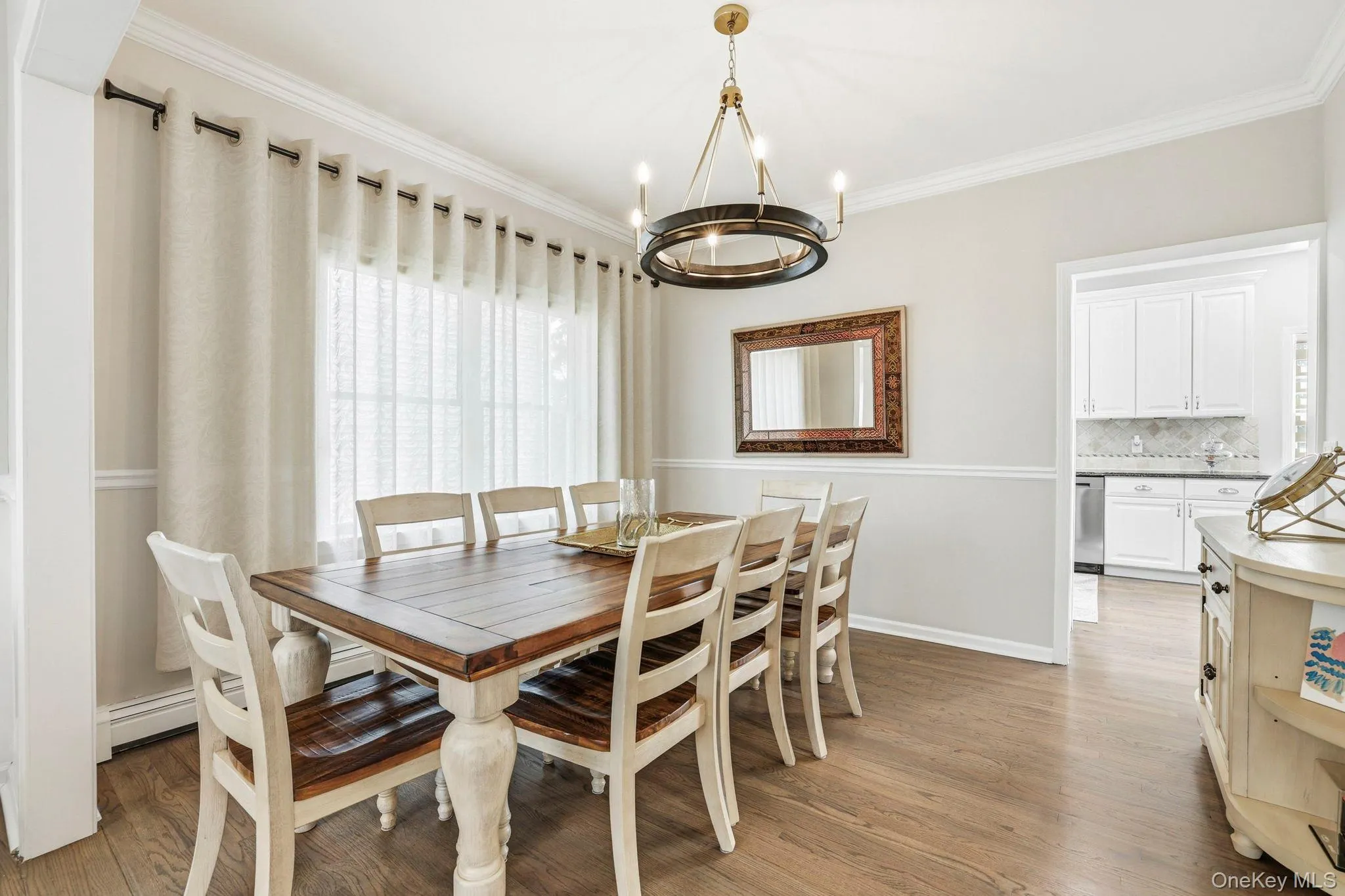 Dining area featuring wood-finish flooring and crown molding Dining area featuring wood-finish flooring and crown molding