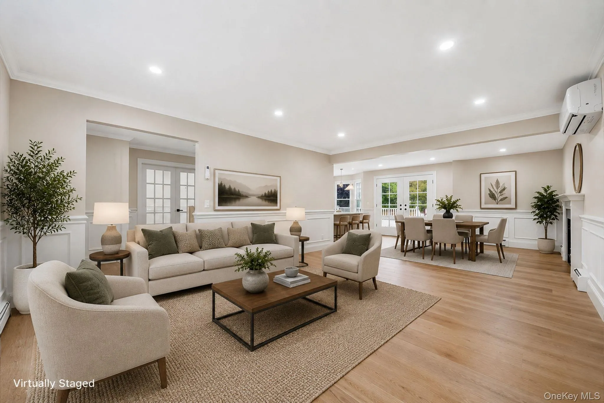 Open-concept living space featuring light wood-finish flooring, recessed lighting, crown molding, and wainscoting Open-concept living space featuring light wood-finish flooring, recessed lighting, crown molding, and wainscoting