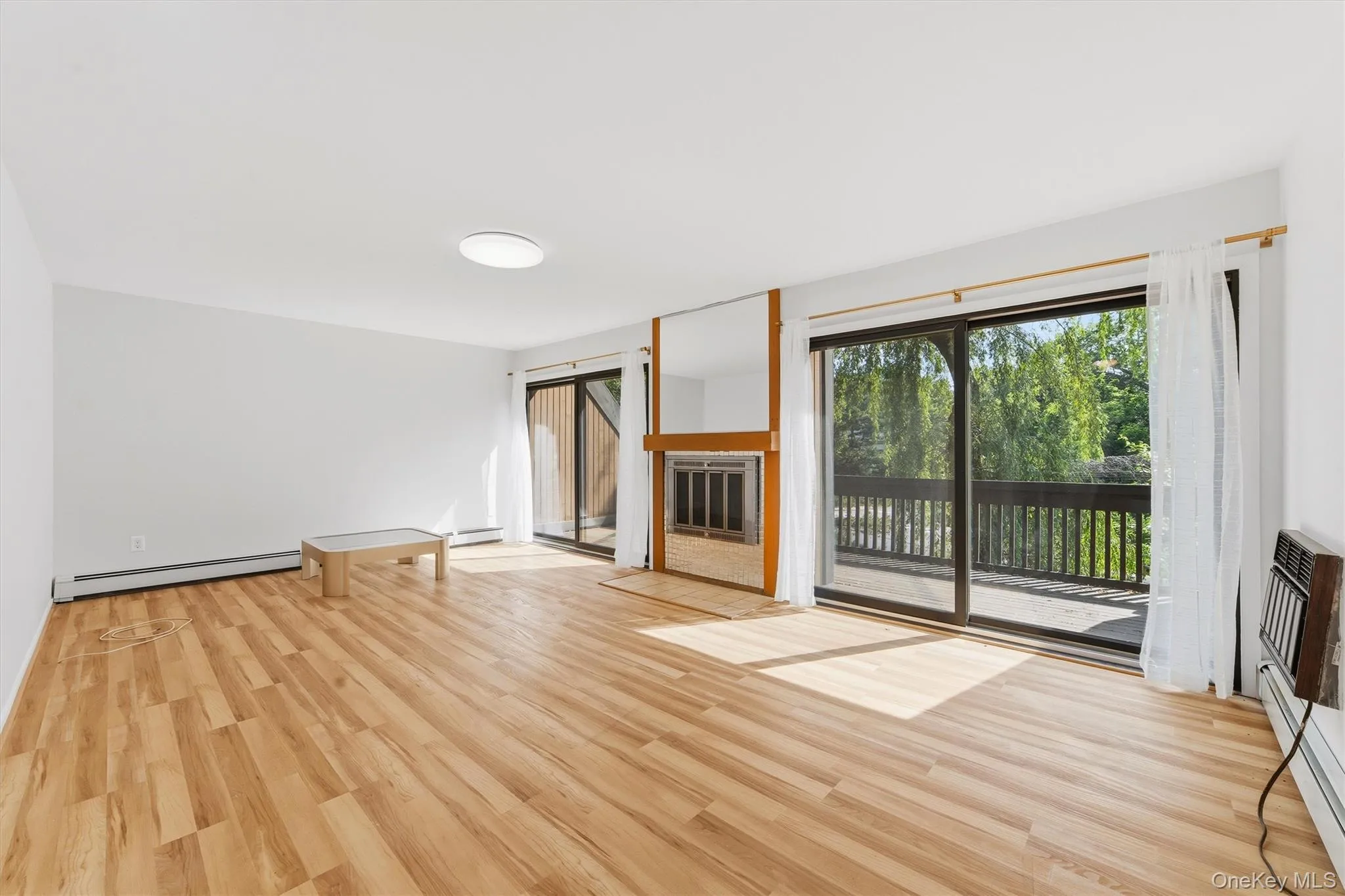 Living room with fireplace and balcony off double sliding doors Living room with fireplace and balcony off double sliding doors