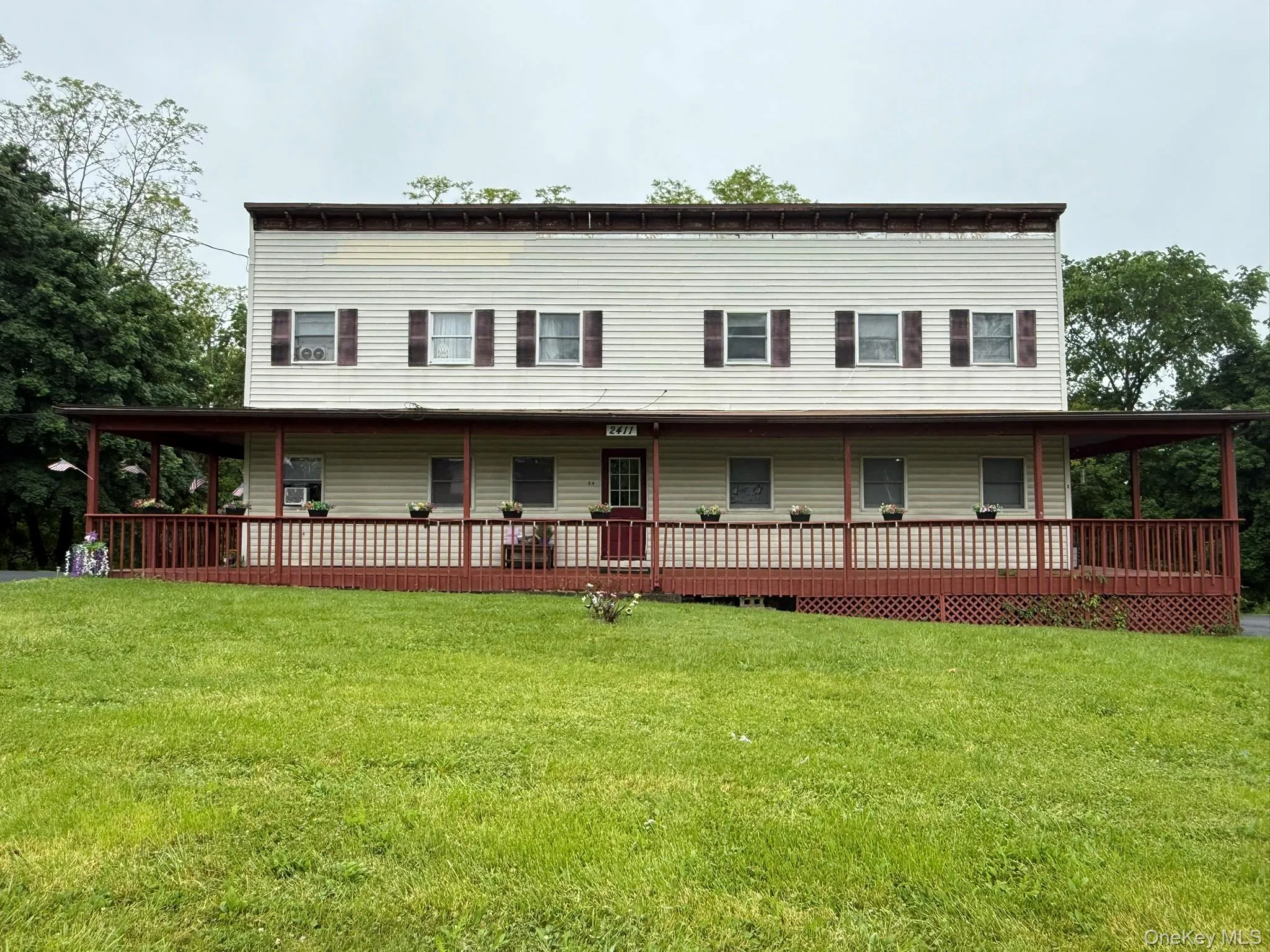 Two-story structure with light-colored horizontal siding and a full-width covered porch Two-story structure with light-colored horizontal siding and a full-width covered porch