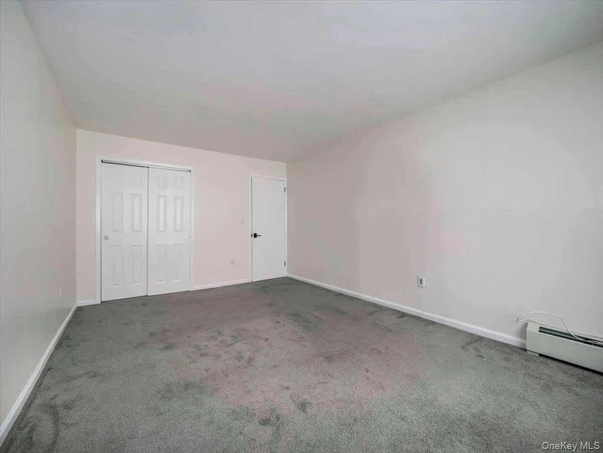 Spacious room featuring neutral carpeting, light-toned walls, and white trim Spacious room featuring neutral carpeting, light-toned walls, and white trim