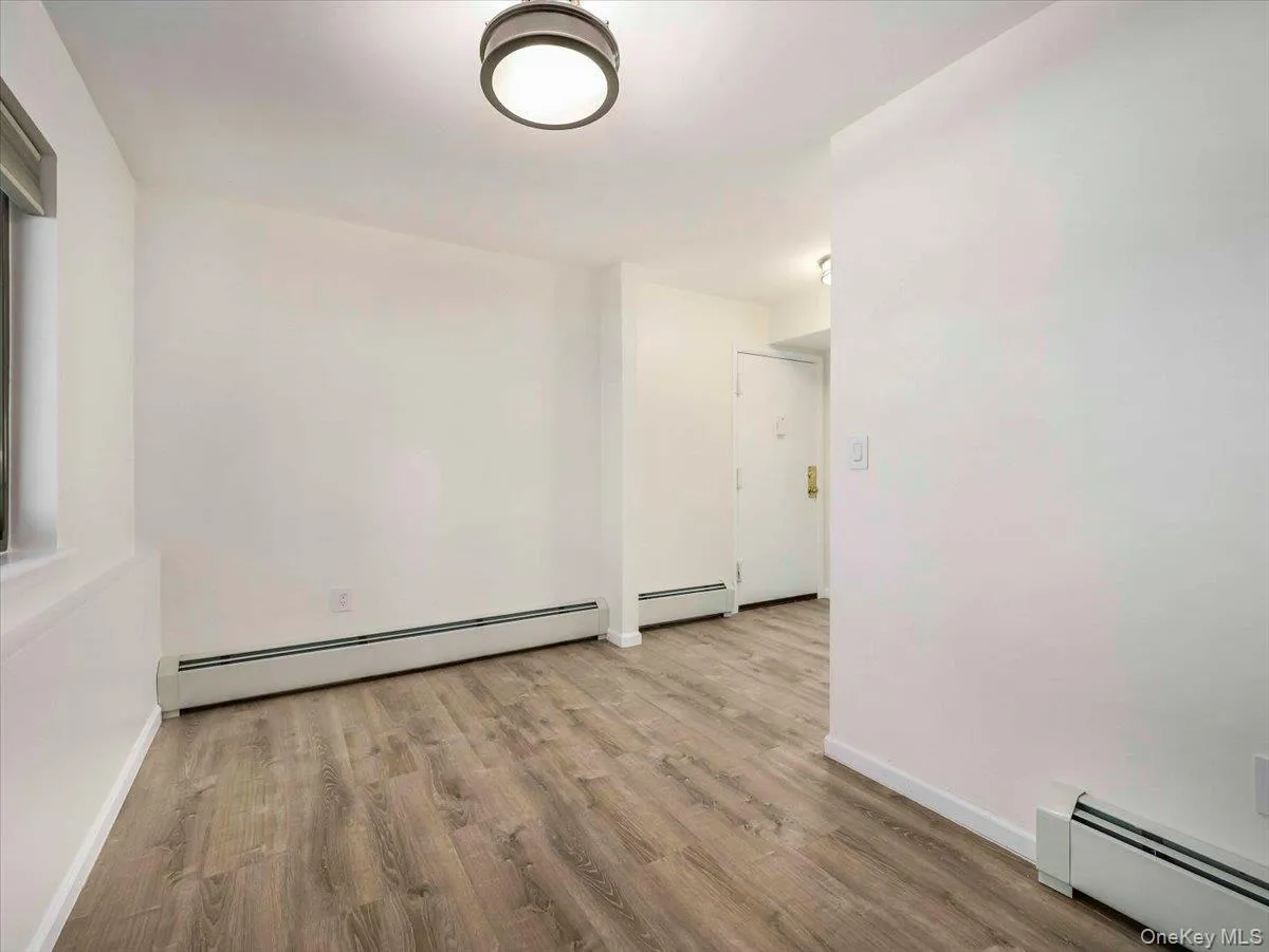Open concept room featuring wood-finish flooring and neutral wall tones Open concept room featuring wood-finish flooring and neutral wall tones