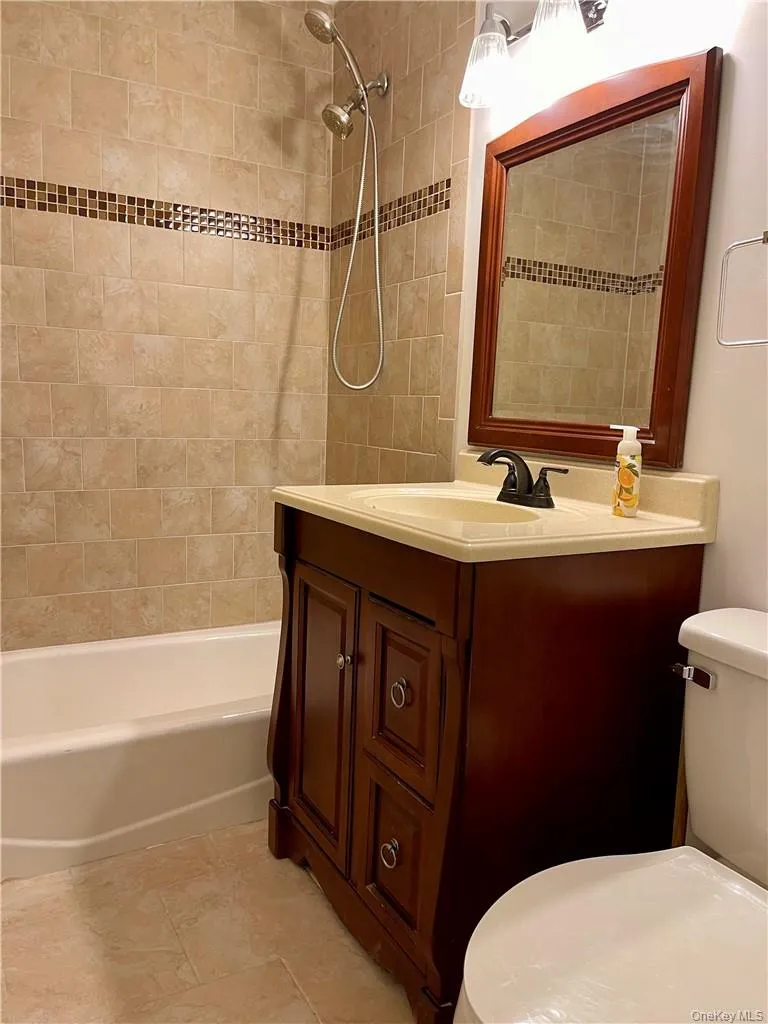 Bathroom featuring a dark wood-finish vanity with a light-toned countertop and integrated sink Bathroom featuring a dark wood-finish vanity with a light-toned countertop and integrated sink