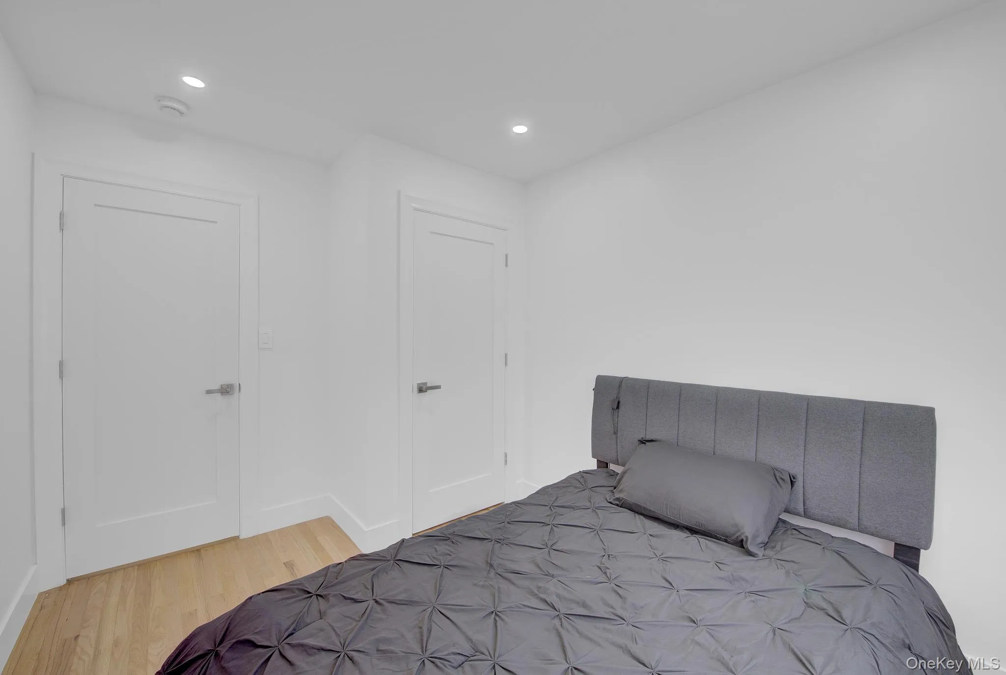 Recessed ceiling lighting illuminates light wood-finish flooring Recessed ceiling lighting illuminates light wood-finish flooring