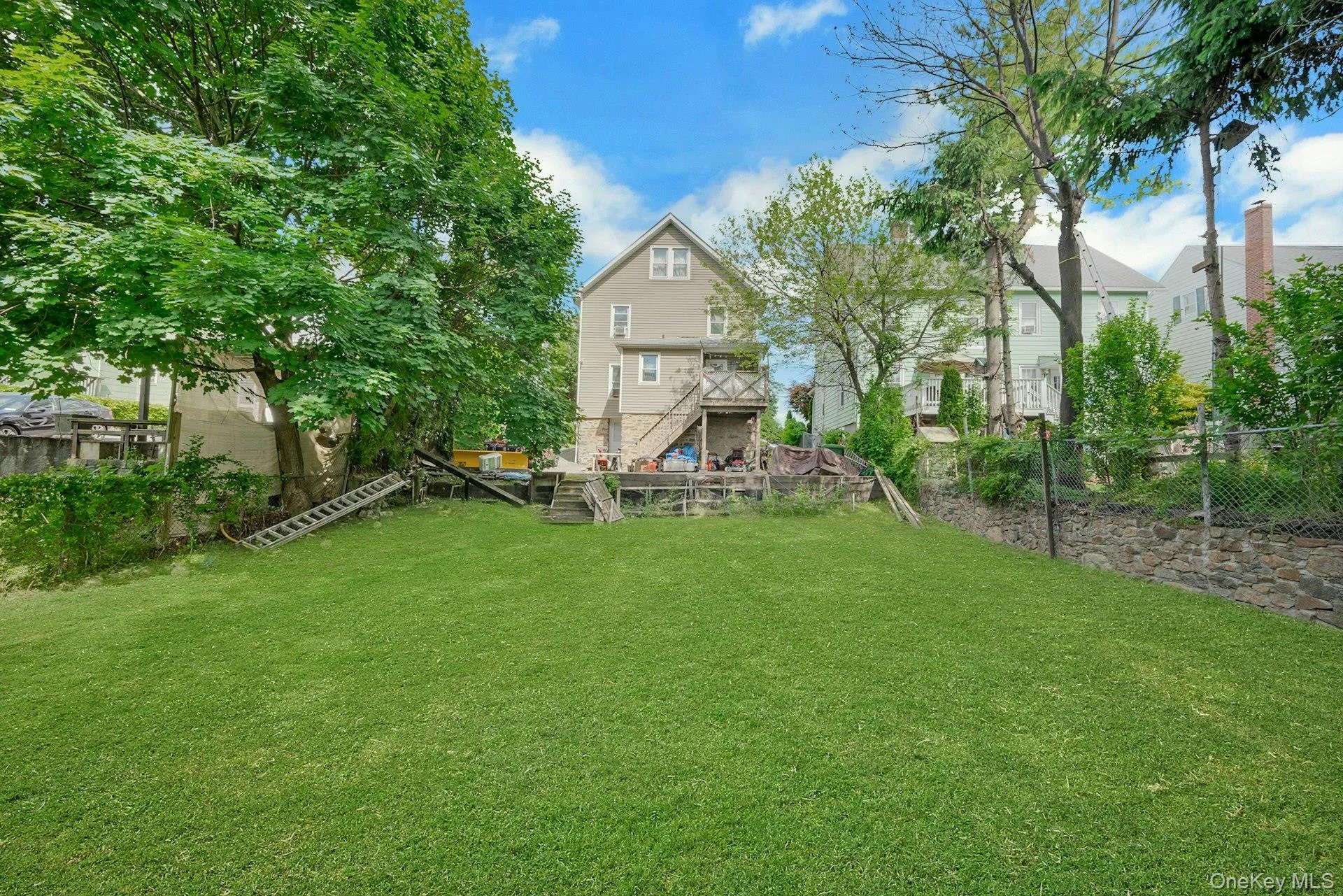 Large back yard with stonewall and fencing Large back yard with stonewall and fencing