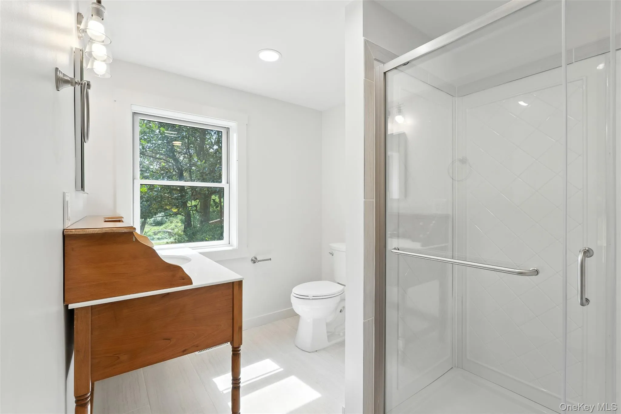 Bathroom featuring a shower stall, vanity, and recessed lighting Bathroom featuring a shower stall, vanity, and recessed lighting