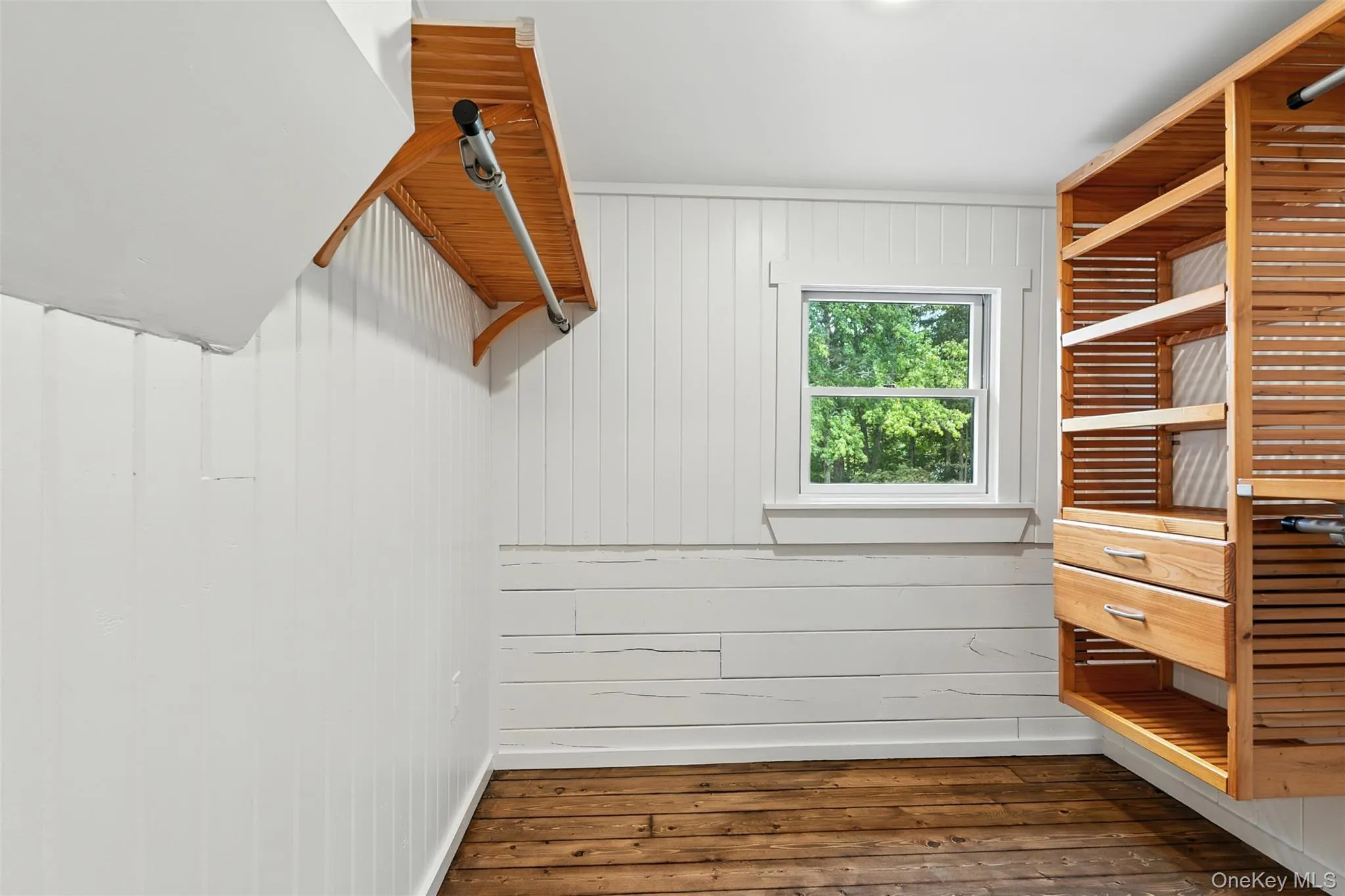 Walk in closet with dark wood-style flooring Walk in closet with dark wood-style flooring