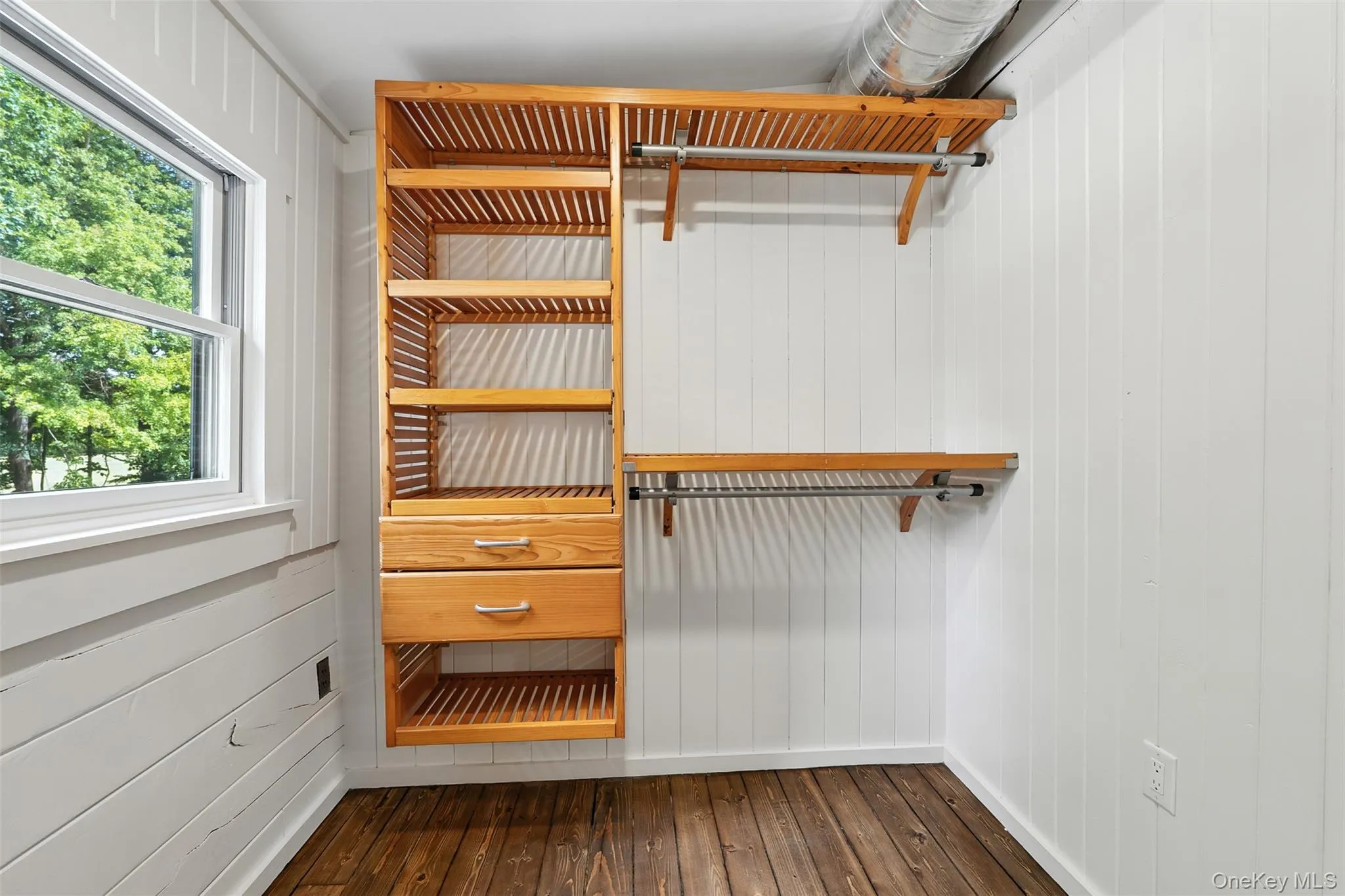 Walk in closet featuring dark wood finished floors Walk in closet featuring dark wood finished floors