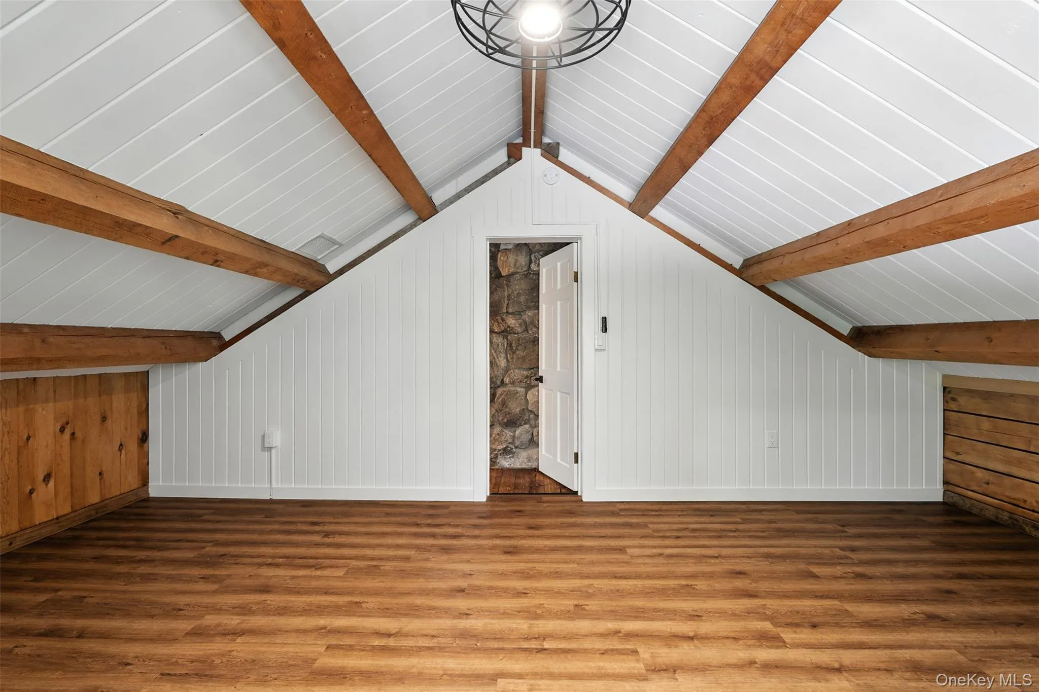 Bonus room featuring wood finished floors and wood walls Bonus room featuring wood finished floors and wood walls