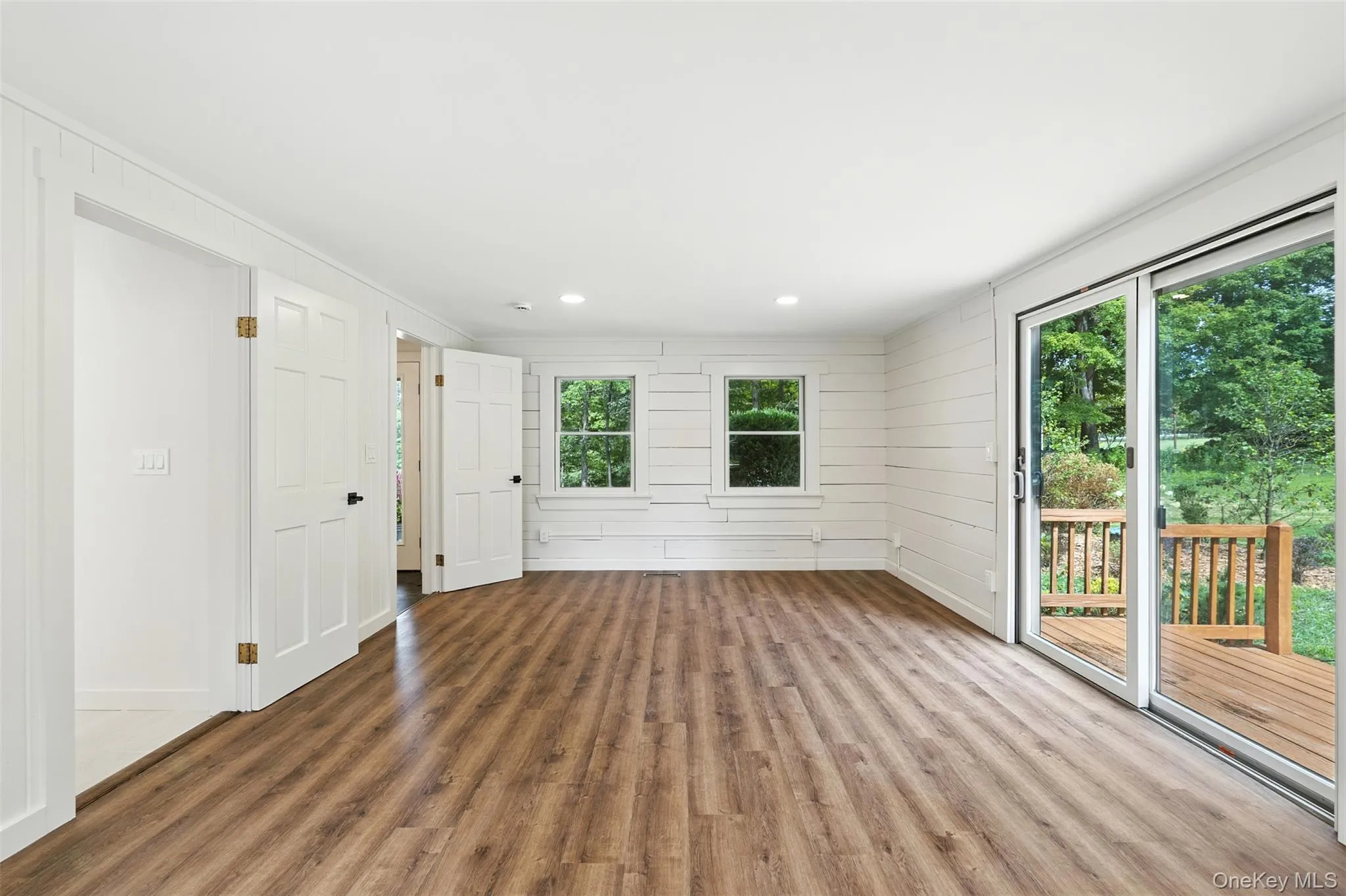 Unfurnished living room featuring wood finished floors, recessed lighting, and ornamental molding Unfurnished living room featuring wood finished floors, recessed lighting, and ornamental molding