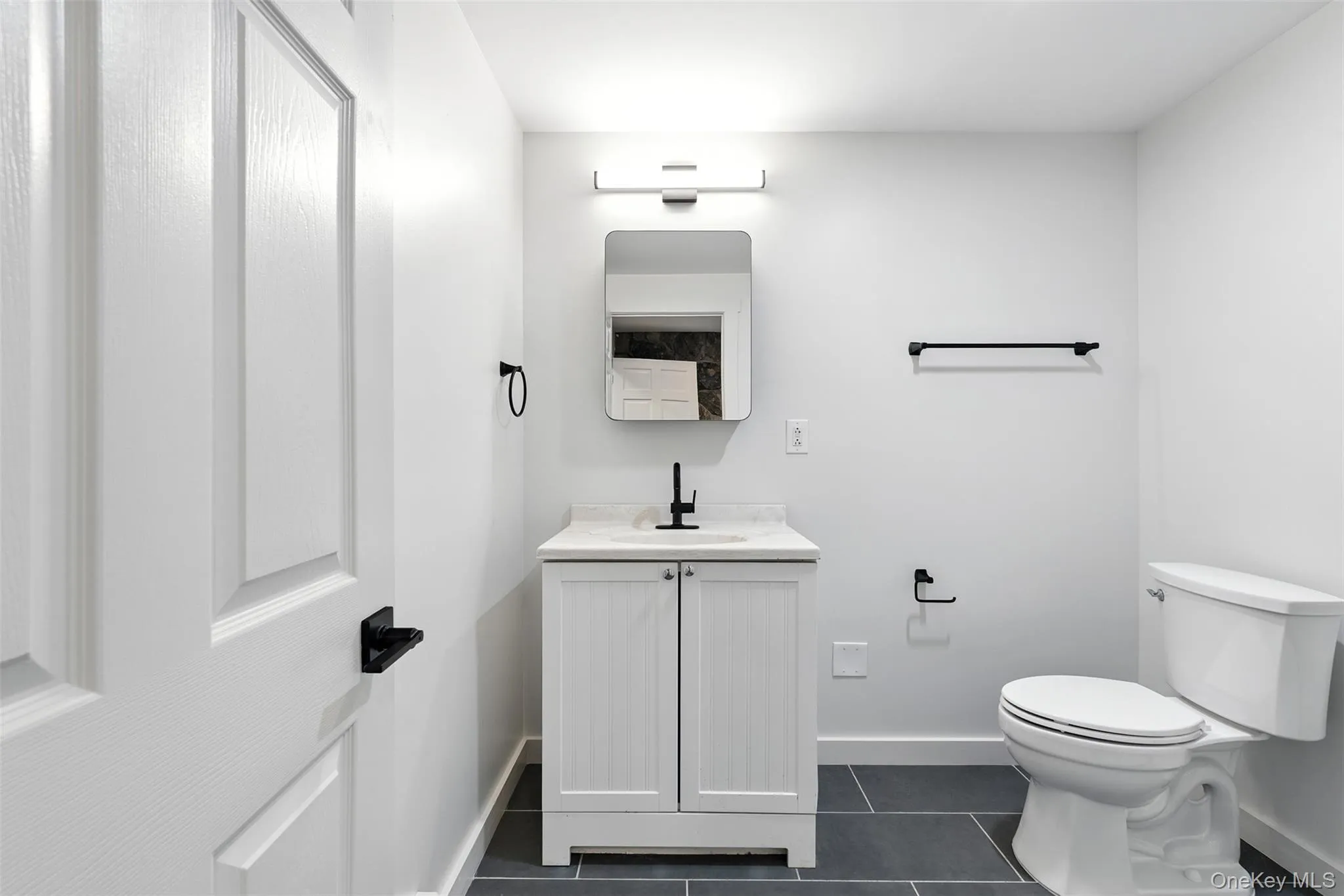 Bathroom with vanity and dark tile patterned floors Bathroom with vanity and dark tile patterned floors