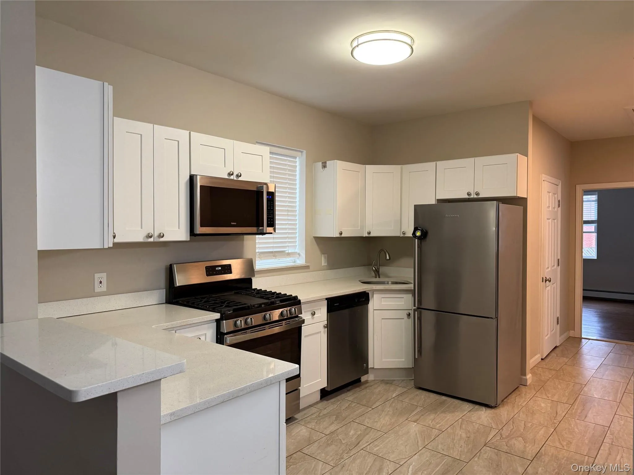 Kitchen with stainless steel appliances, white cabinetry, and a peninsula Kitchen with stainless steel appliances, white cabinetry, and a peninsula