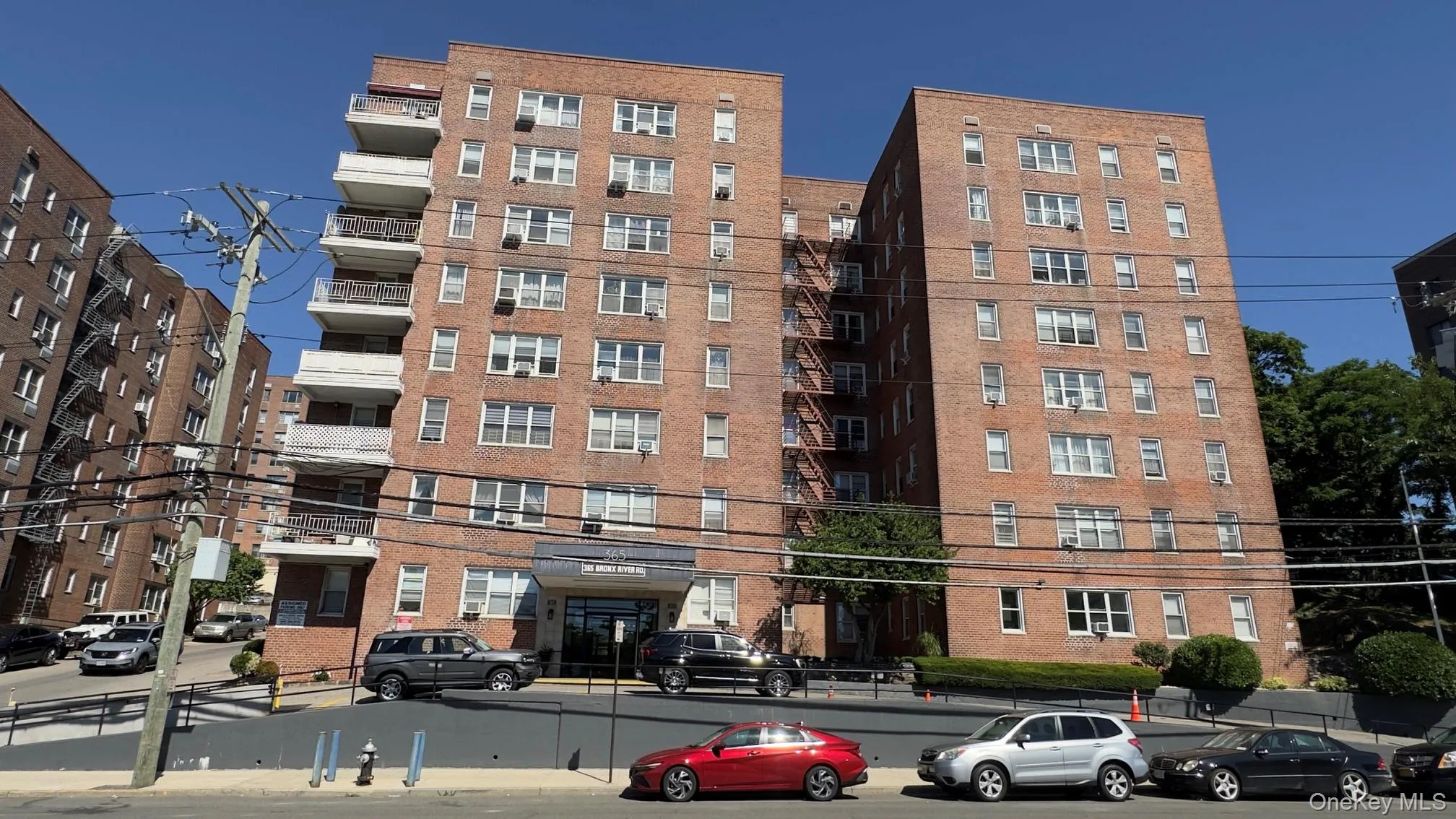 Brick multi-story building featuring multiple balconies and numerous windows Brick multi-story building featuring multiple balconies and numerous windows