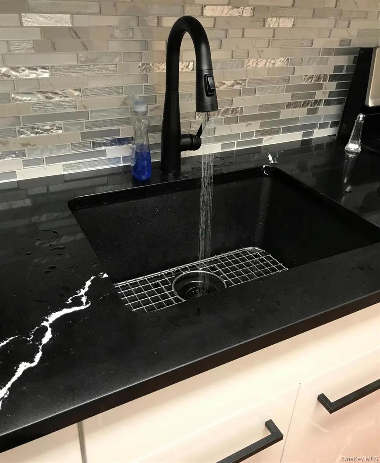 Modern kitchen featuring a large deep farmhouse sink with a matte black high-arc pull down faucet Modern kitchen featuring a large deep farmhouse sink with a matte black high-arc pull down faucet