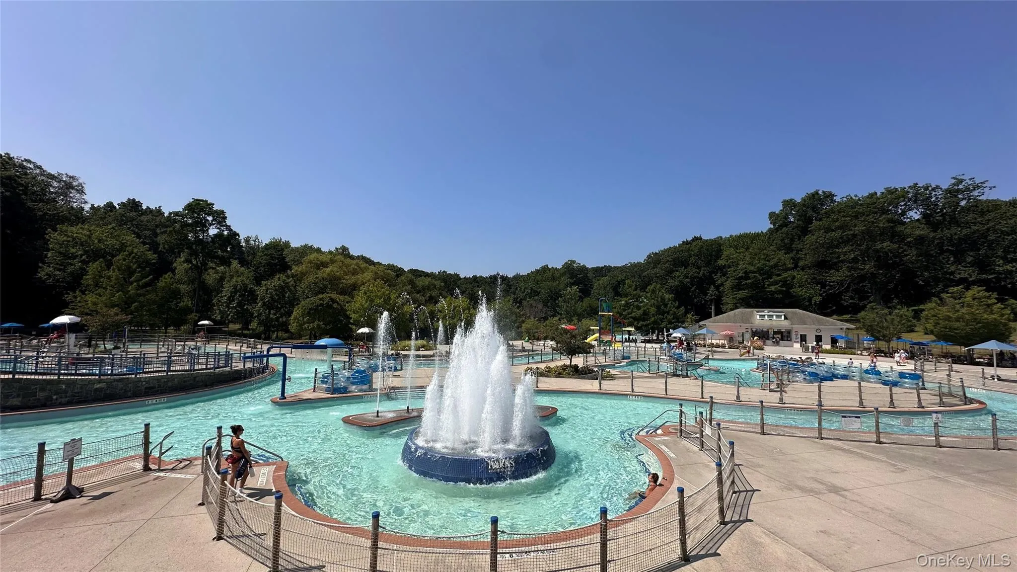 Tibbetts Brook Park: Expansive aquatic park featuring a lazy river, multiple swimming areas, a central fountain, and a large recreational building Tibbetts Brook Park: Expansive aquatic park featuring a lazy river, multiple swimming areas, a central fountain, and a large recreational building