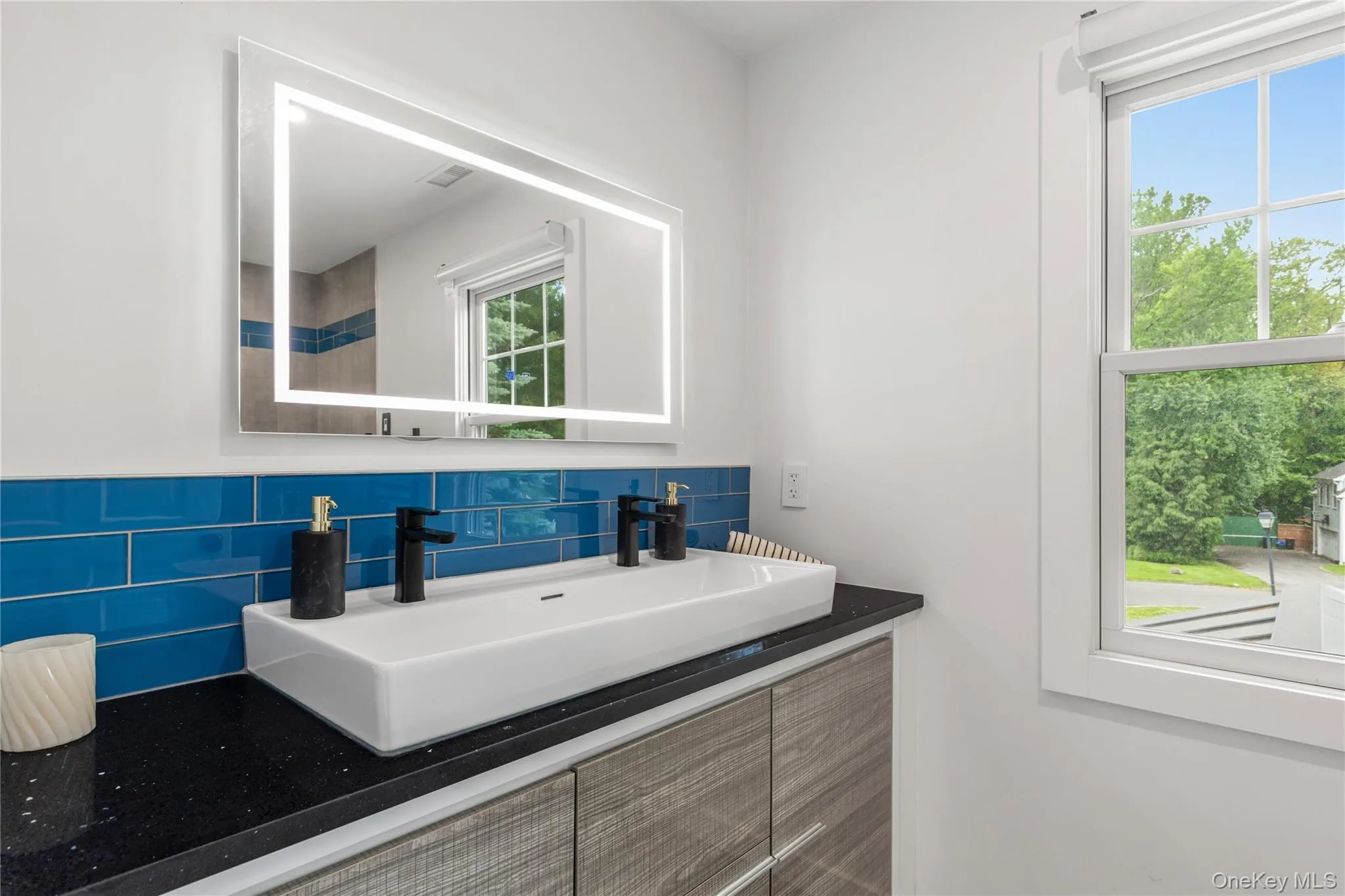 The bright, renovated hall bathroom serves two bedrooms, has a double vanity and storage drawers. The bright, renovated hall bathroom serves two bedrooms, has a double vanity and storage drawers.