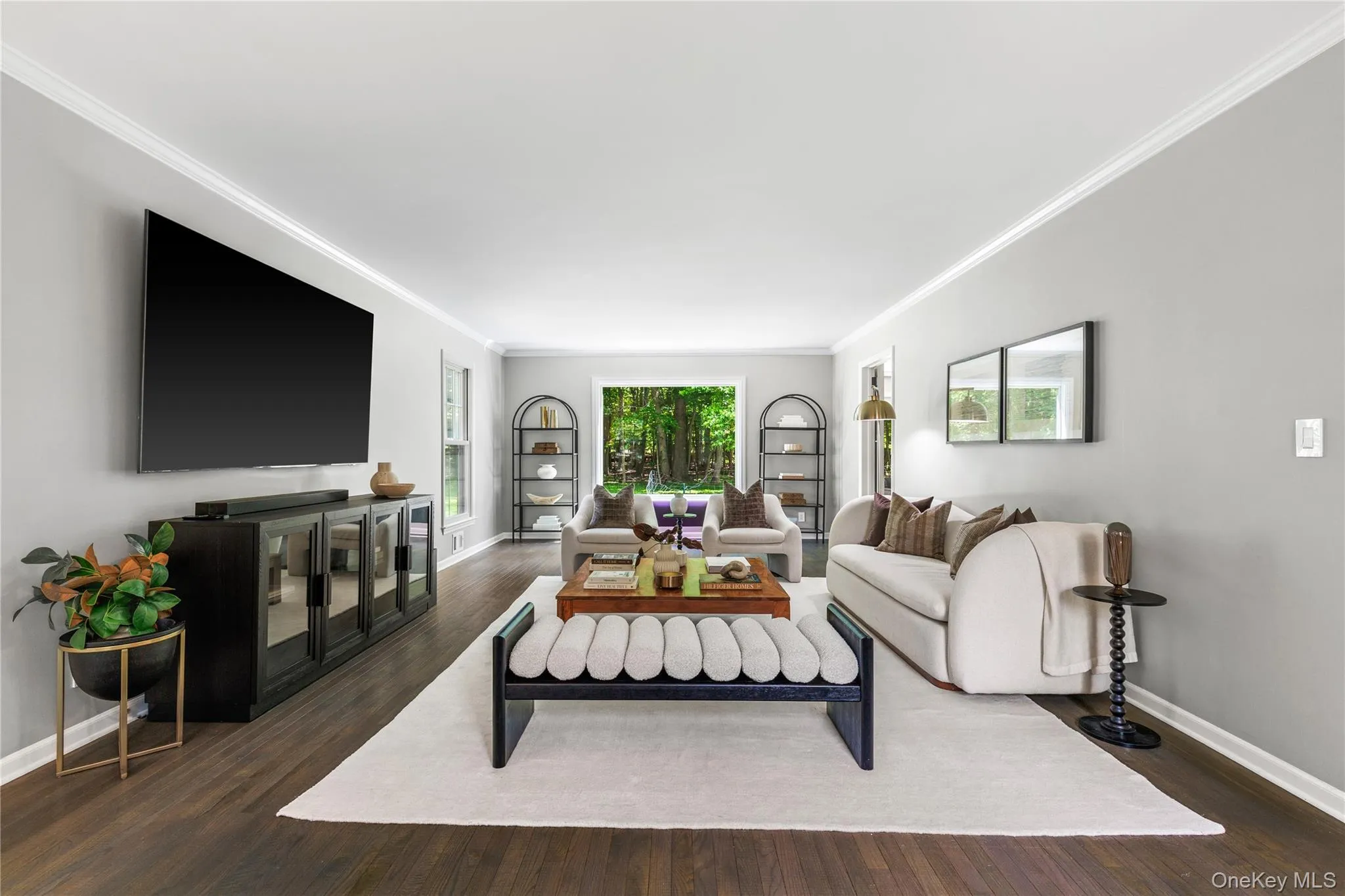 The large picture window frames the trees and their foliage, directing attention from the sophisticated interior to the lush outdoors. The large picture window frames the trees and their foliage, directing attention from the sophisticated interior to the lush outdoors.