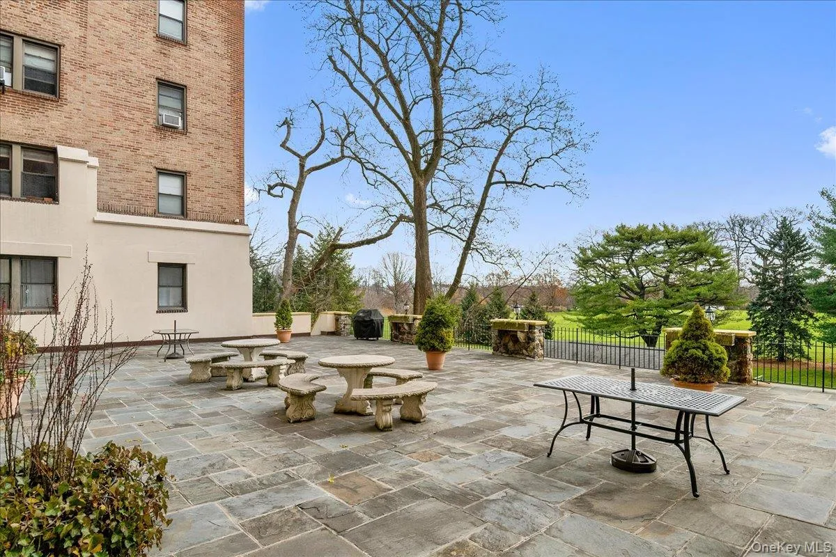 Expansive stone patio featuring multiple stone picnic tables, an integrated grill area, over looking country club golf course Expansive stone patio featuring multiple stone picnic tables, an integrated grill area, over looking country club golf course
