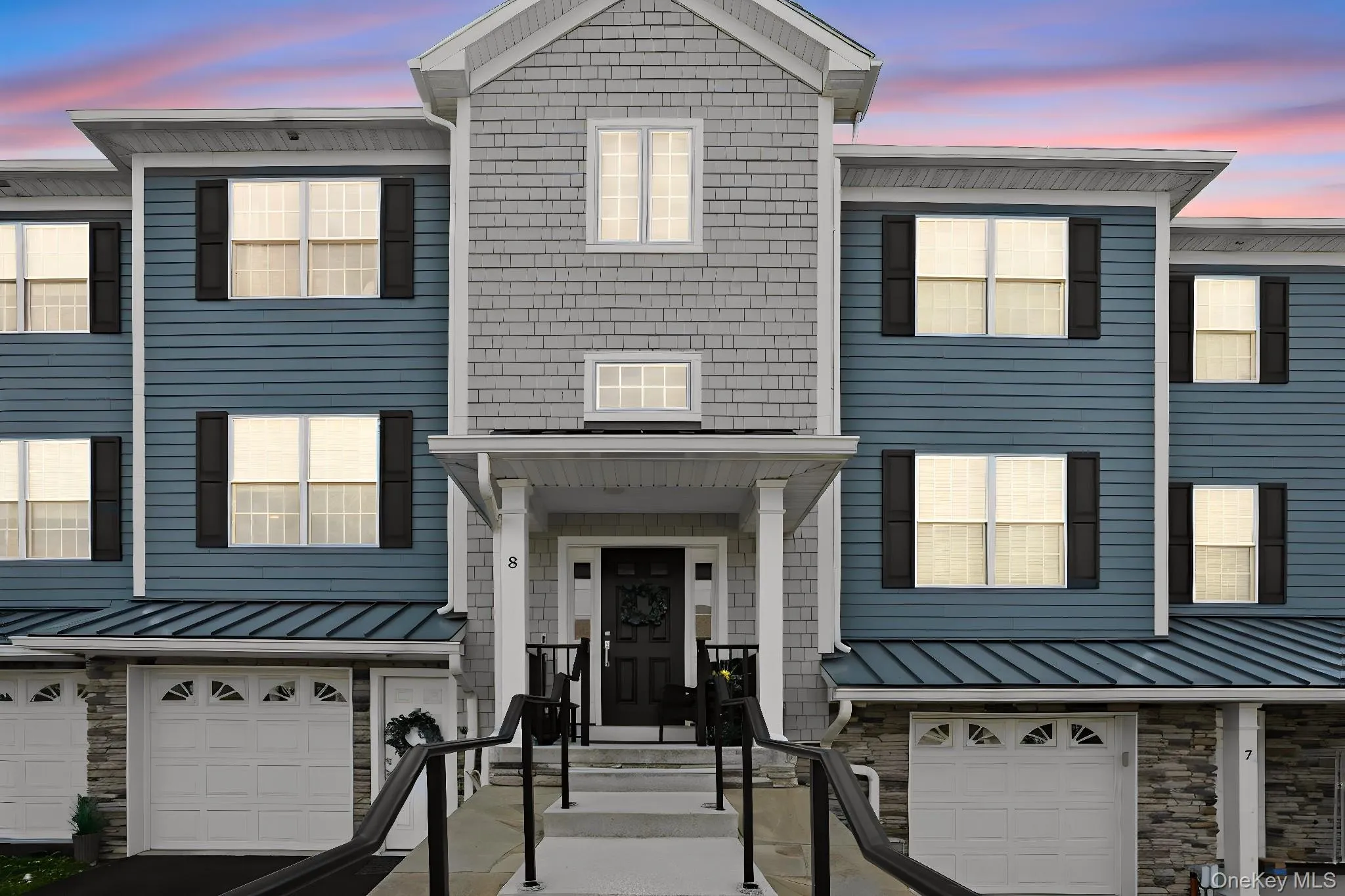 Multi-level townhouse exterior featuring blue horizontal siding and gray shingle-style siding Multi-level townhouse exterior featuring blue horizontal siding and gray shingle-style siding