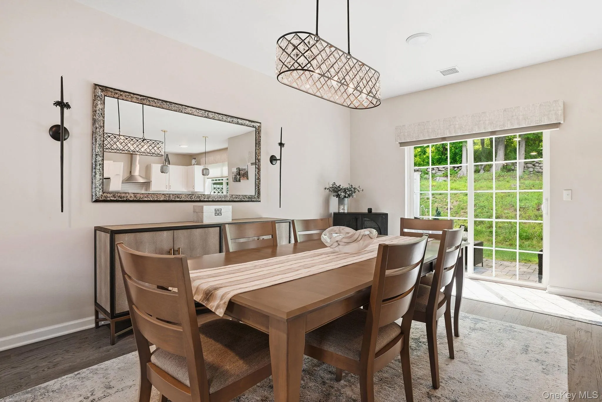 Dining area featuring dark wood-finish flooring and a contemporary chandelier Dining area featuring dark wood-finish flooring and a contemporary chandelier