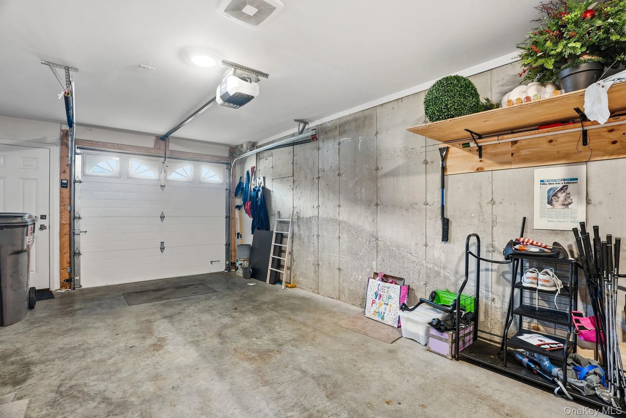Single-car garage featuring a concrete floor and exposed foundation walls Single-car garage featuring a concrete floor and exposed foundation walls