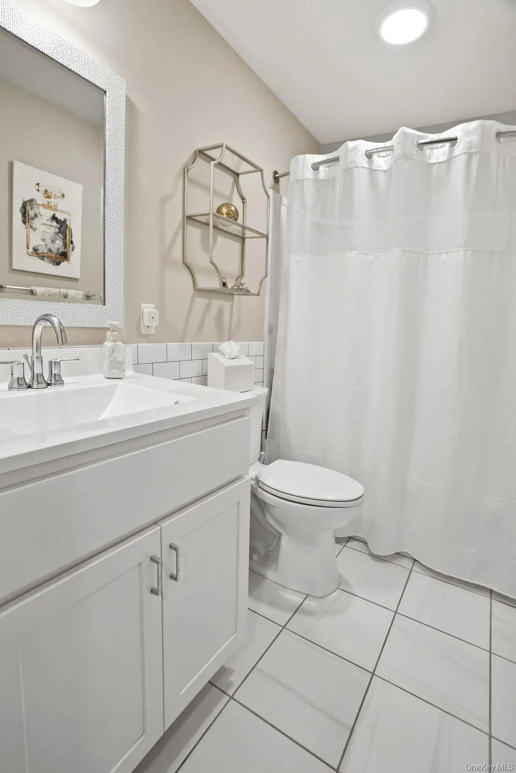 Upstairs hallway bathroom featuring a white vanity with integrated sink, chrome faucet, and white subway tile backsplash Upstairs hallway bathroom featuring a white vanity with integrated sink, chrome faucet, and white subway tile backsplash