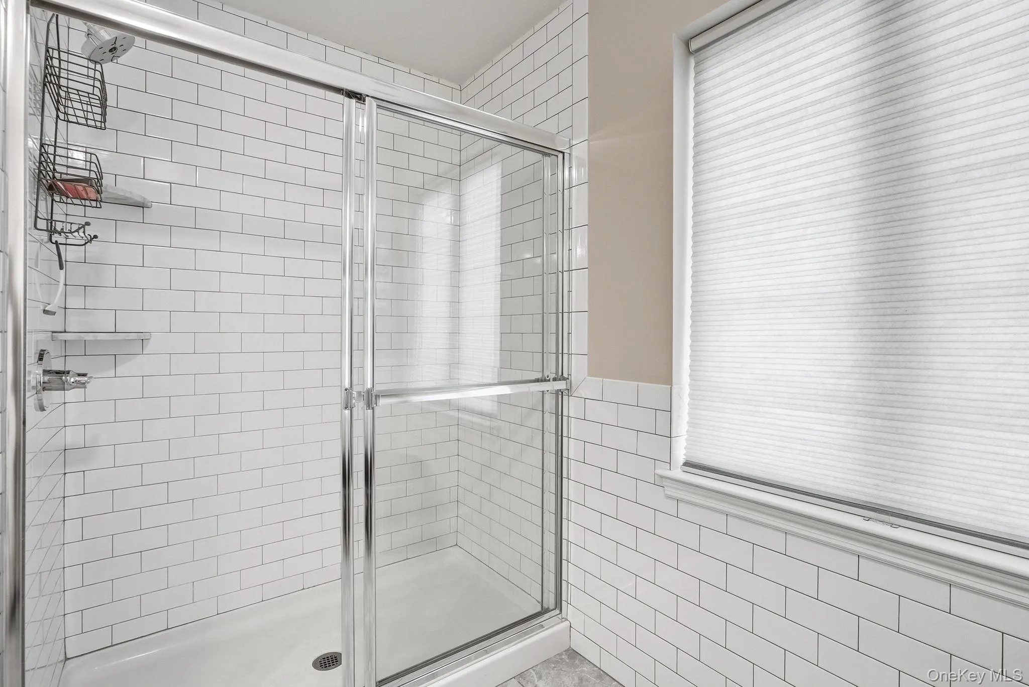 Primary bathroom featuring shower enclosure with clear glass sliding doors and polished chrome hardware Primary bathroom featuring shower enclosure with clear glass sliding doors and polished chrome hardware