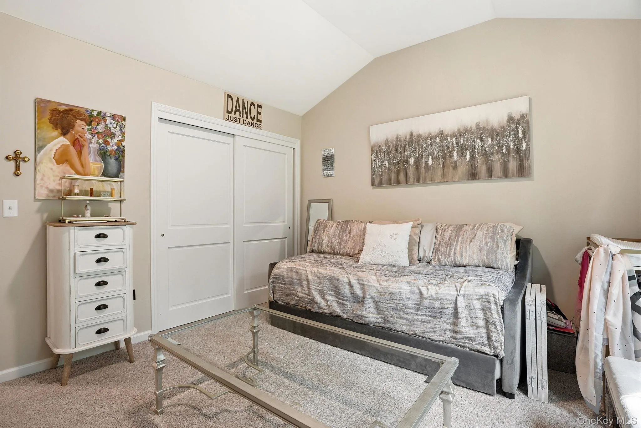 Second bedroom featuring a vaulted ceiling and neutral wall tones Second bedroom featuring a vaulted ceiling and neutral wall tones