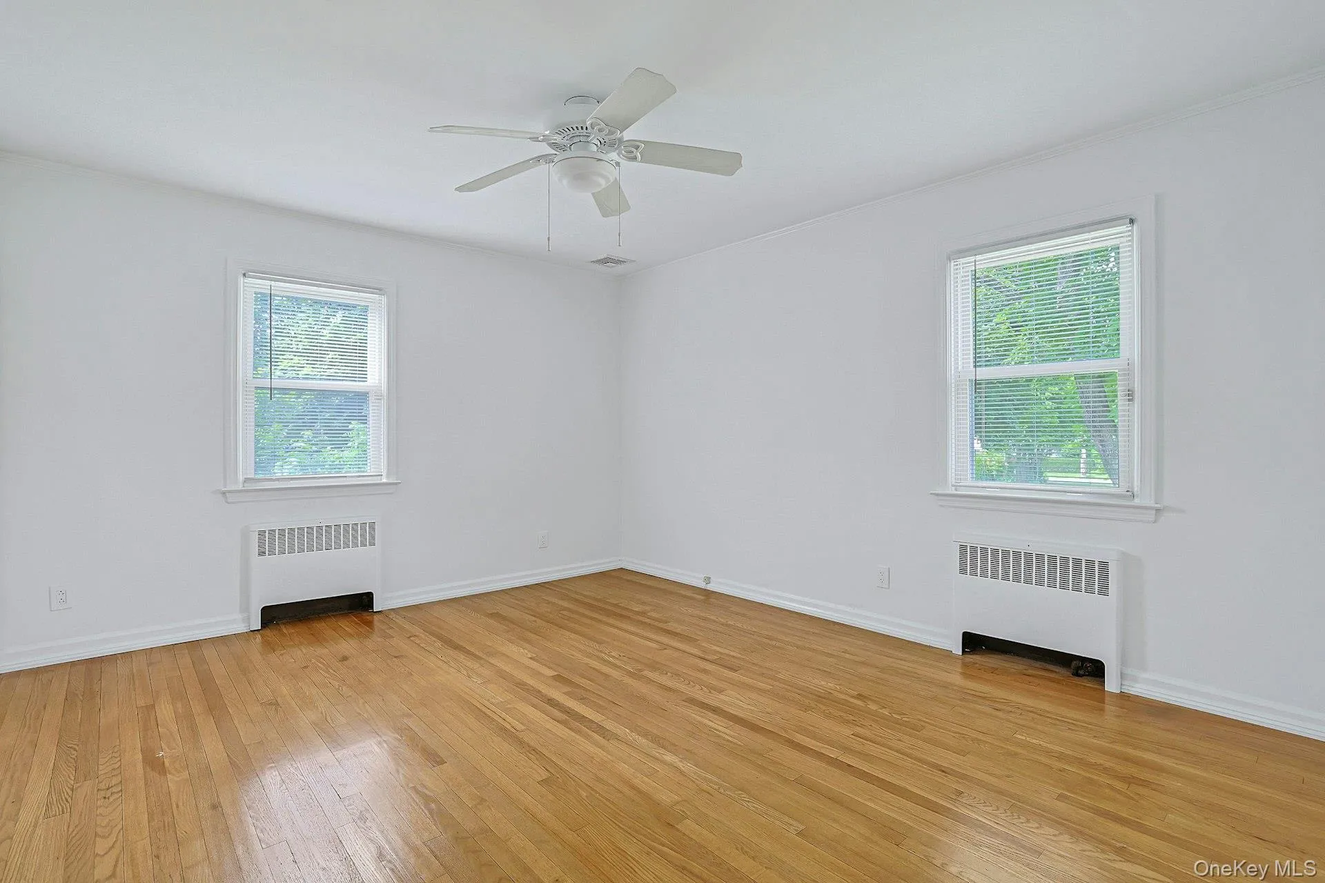 Primary Bedroom with hardwood flooring and lots of natural light Primary Bedroom with hardwood flooring and lots of natural light