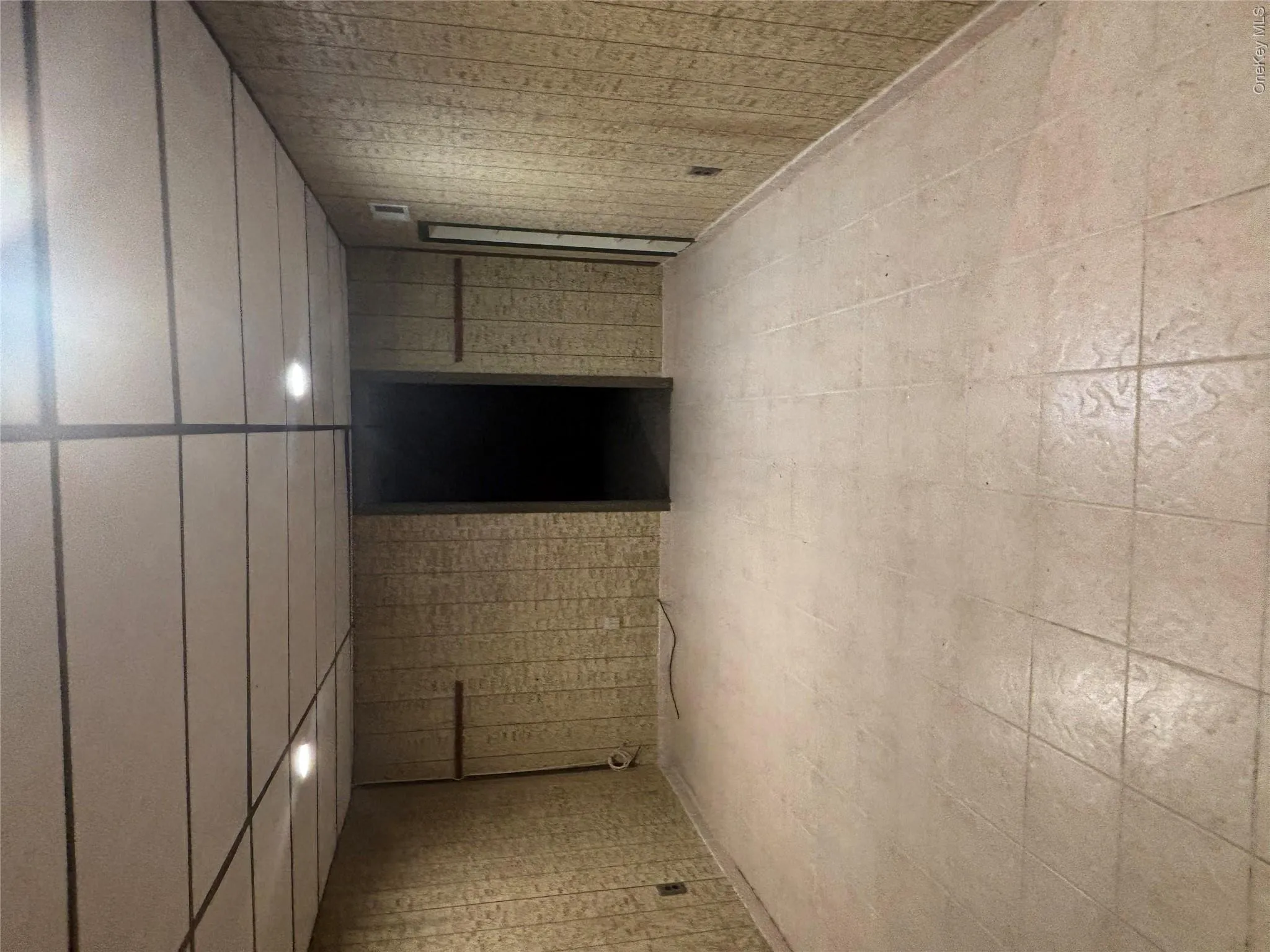 Full basement featuring textured wall paneling and a drop ceiling with recessed lighting Full basement featuring textured wall paneling and a drop ceiling with recessed lighting