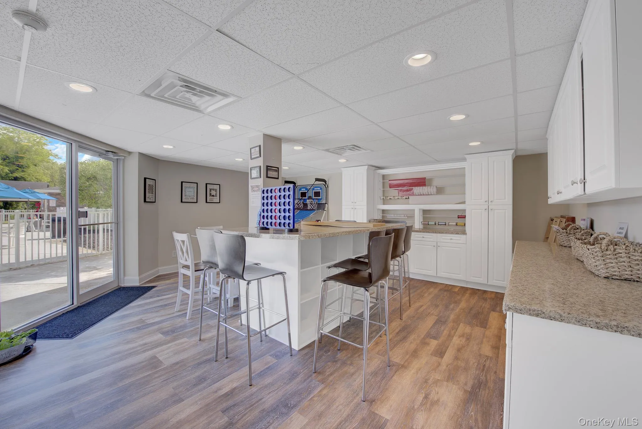 Spacious interior featuring wood-finish flooring, recessed lighting, and a drop ceiling Spacious interior featuring wood-finish flooring, recessed lighting, and a drop ceiling