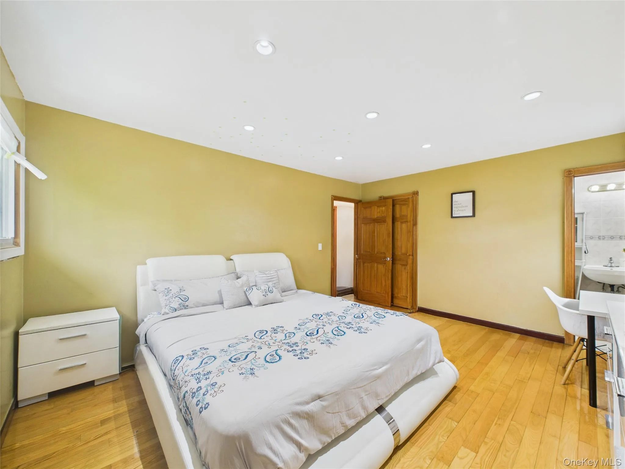 Bedroom featuring light wood-style floors, baseboards, recessed lighting, and a sink Bedroom featuring light wood-style floors, baseboards, recessed lighting, and a sink