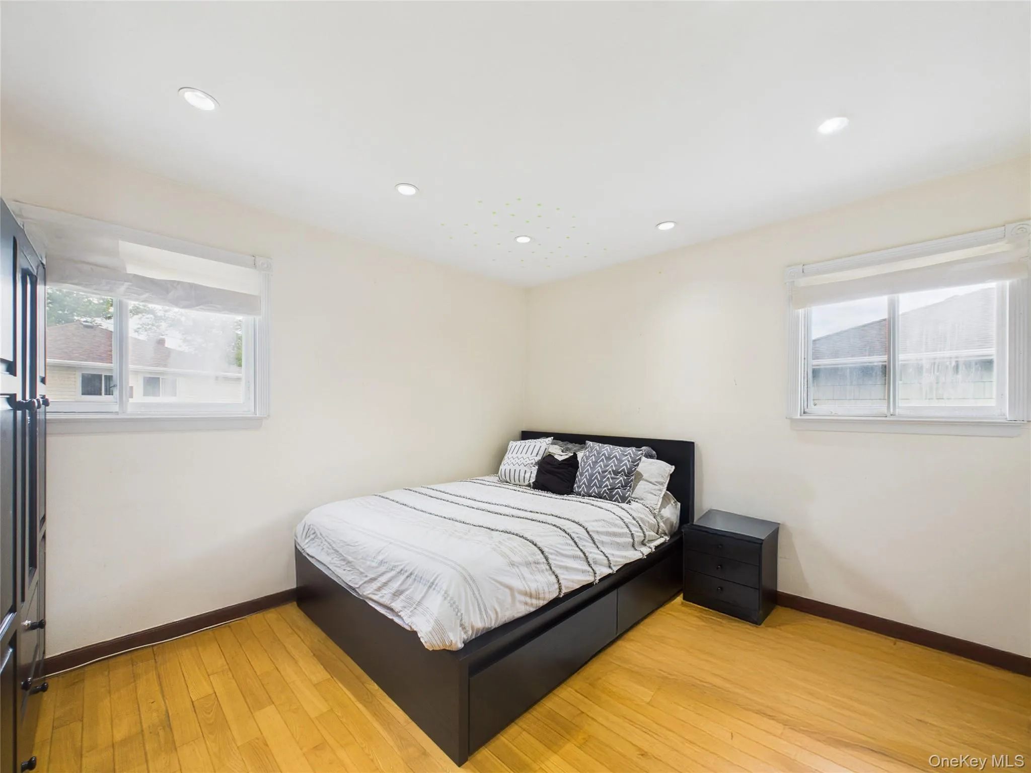 Bedroom featuring baseboards, light wood-style floors, and recessed lighting Bedroom featuring baseboards, light wood-style floors, and recessed lighting